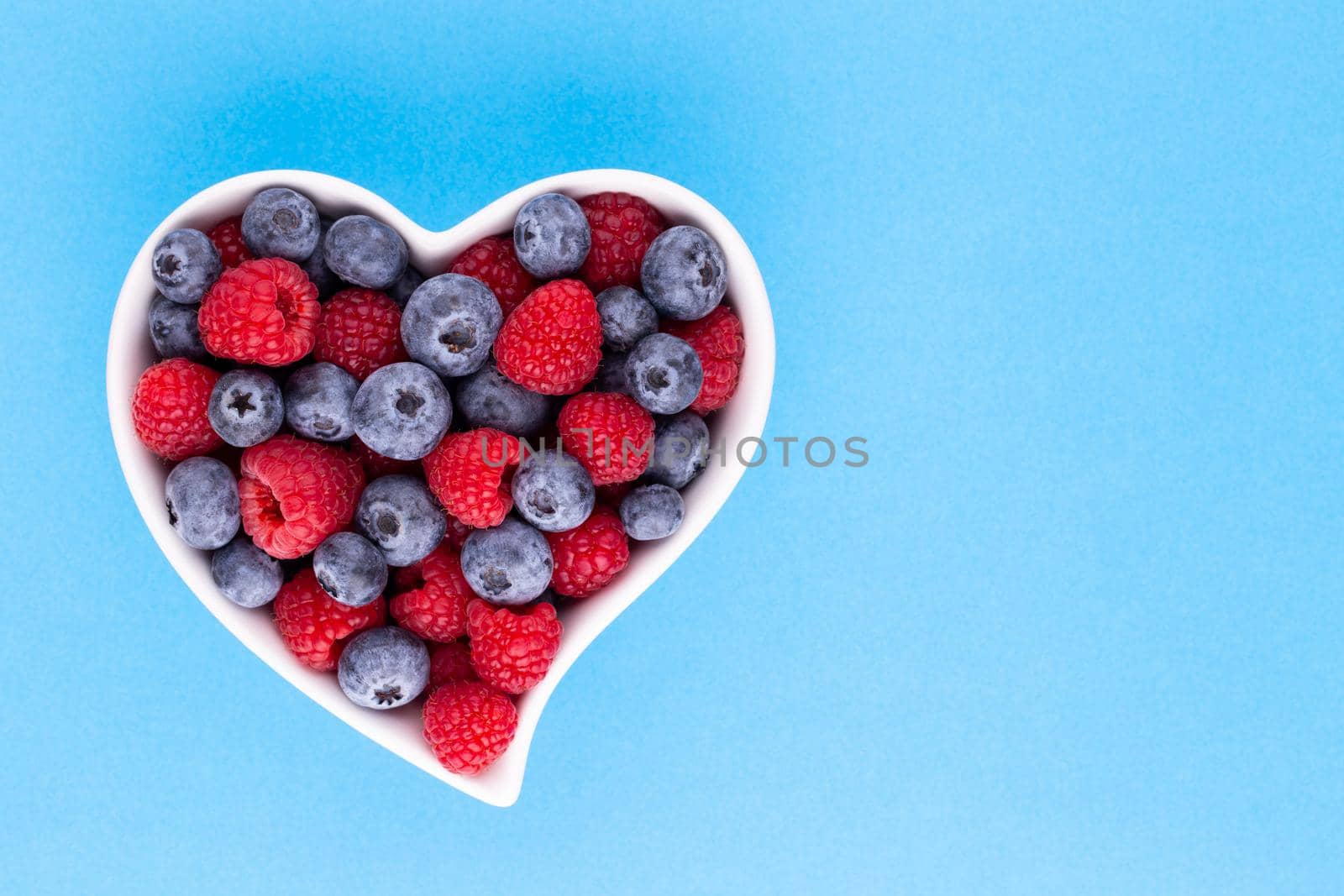 Creative layout made of Blueberry and raspberries on pastel background. Food ingredient pattern. by gitusik