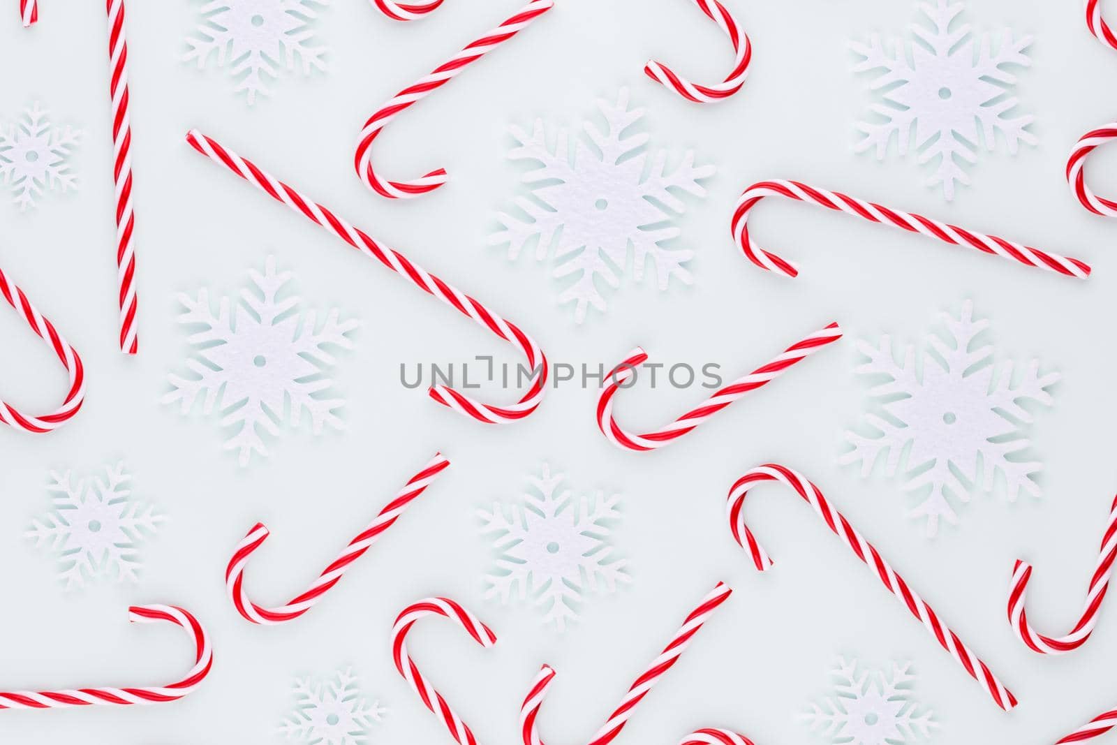 Christmas candy cane lied on blue background. Flat lay and top view. by gitusik
