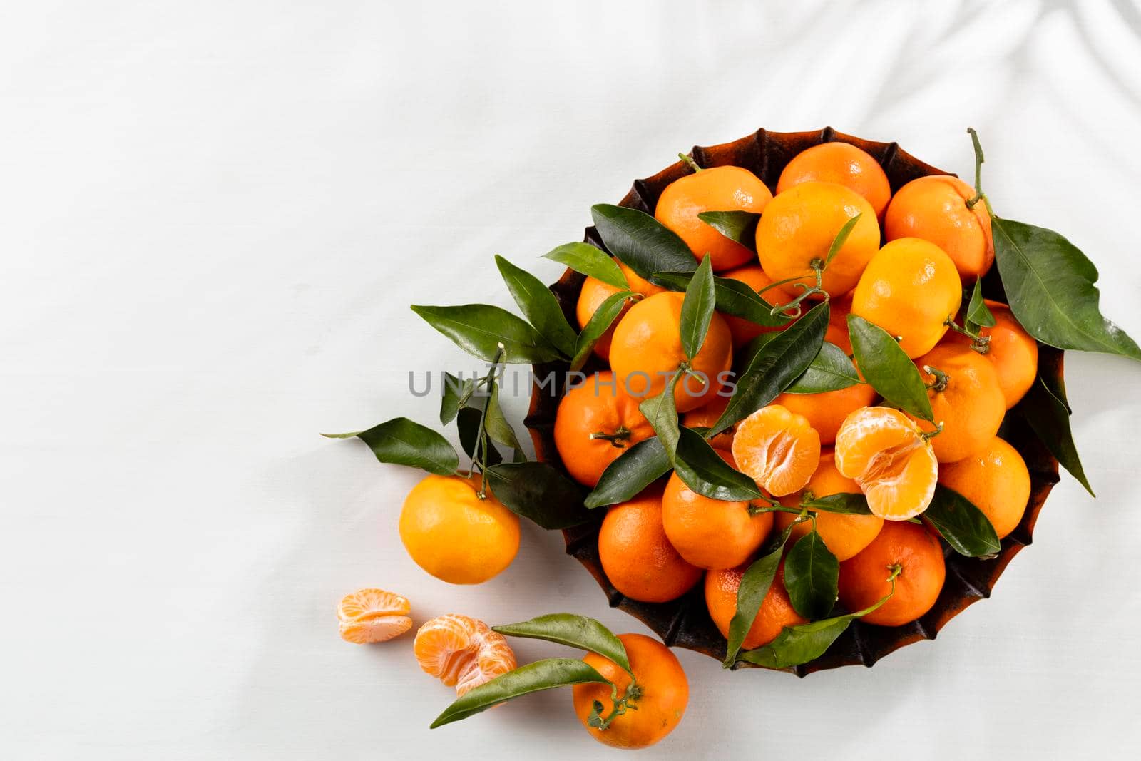 Fresh mandarin oranges fruit with leaves in wooden box, top view. by gitusik