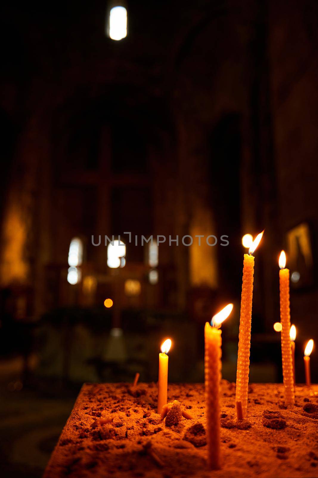Burning candles in a church on a dark background. Memorial Candles. Burning Candles In The Temple, Sacred Fire. Candles Burning in Dark Church.