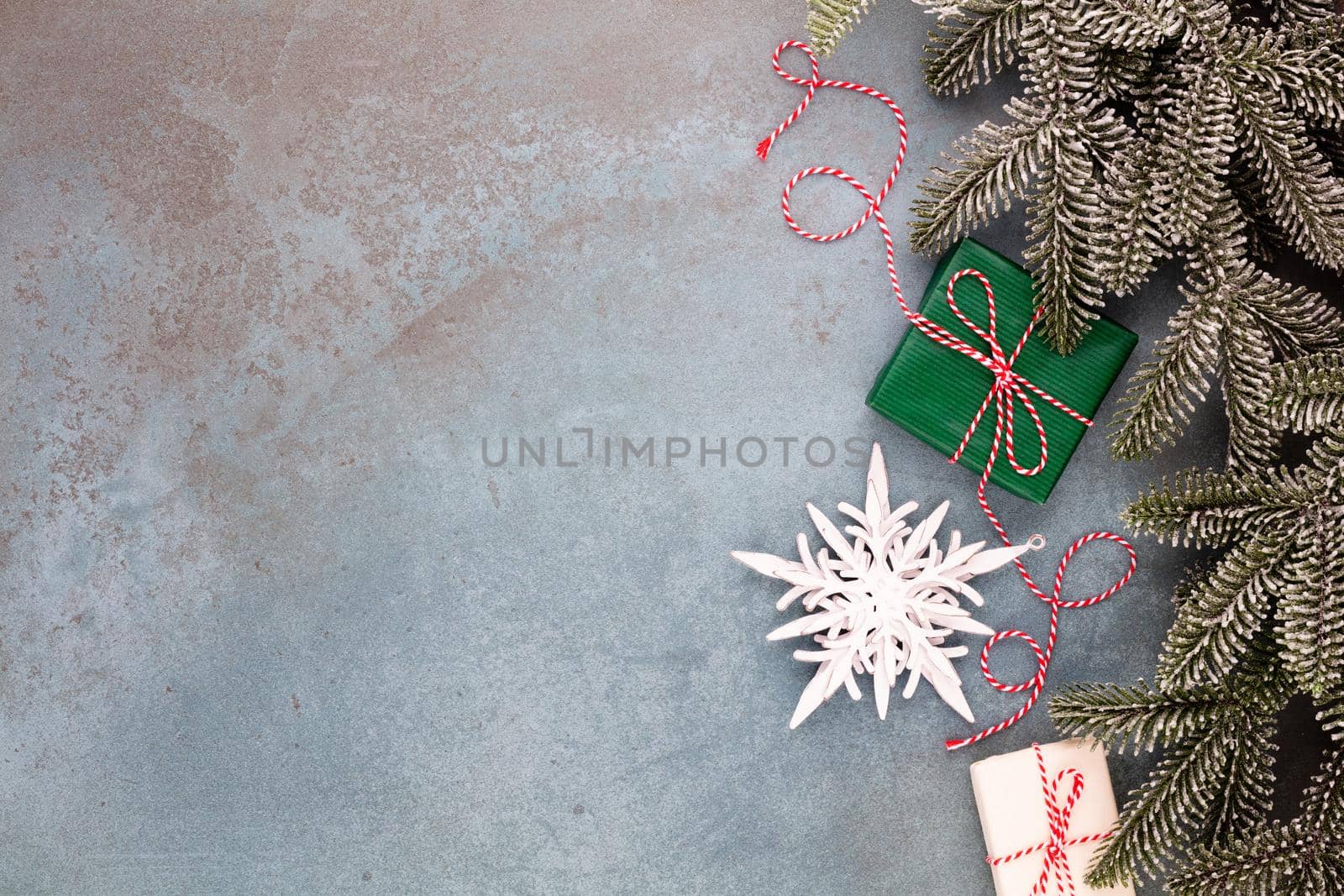 Christmas composition fir tree branches, star ornaments on blue background. by gitusik