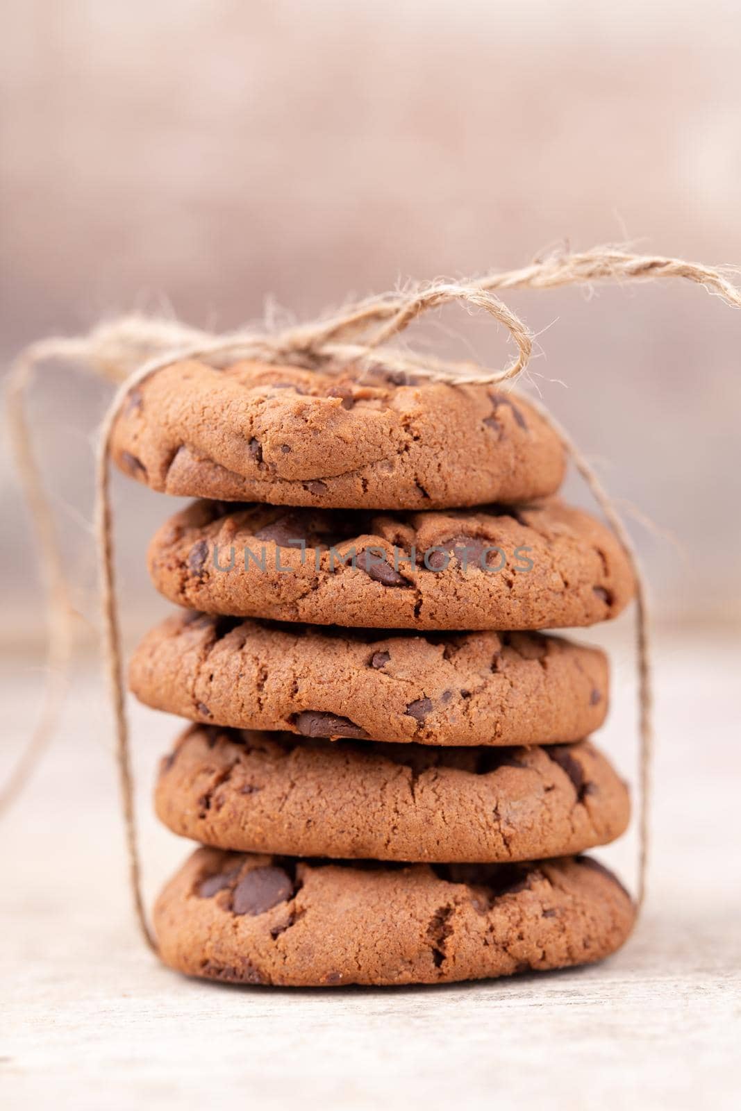 Image shows a stack of american chocolate chip cookies on rustic wooden plank. by gitusik