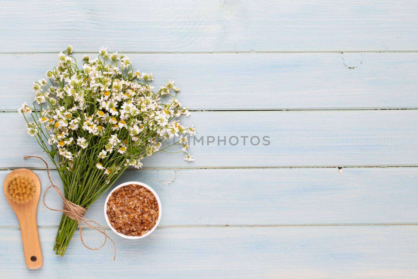 Spa aromatherapy background, flat lay of various beauty care products decorated with simple chamomile flowers.