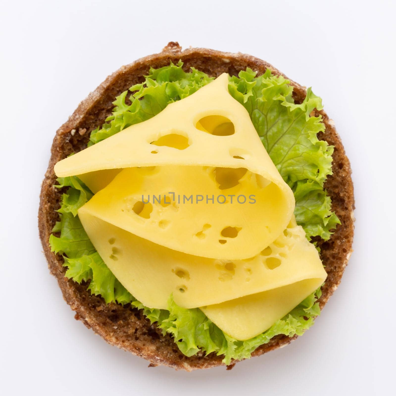 Sandwich with cheese, lettuce, tomato, on white background.