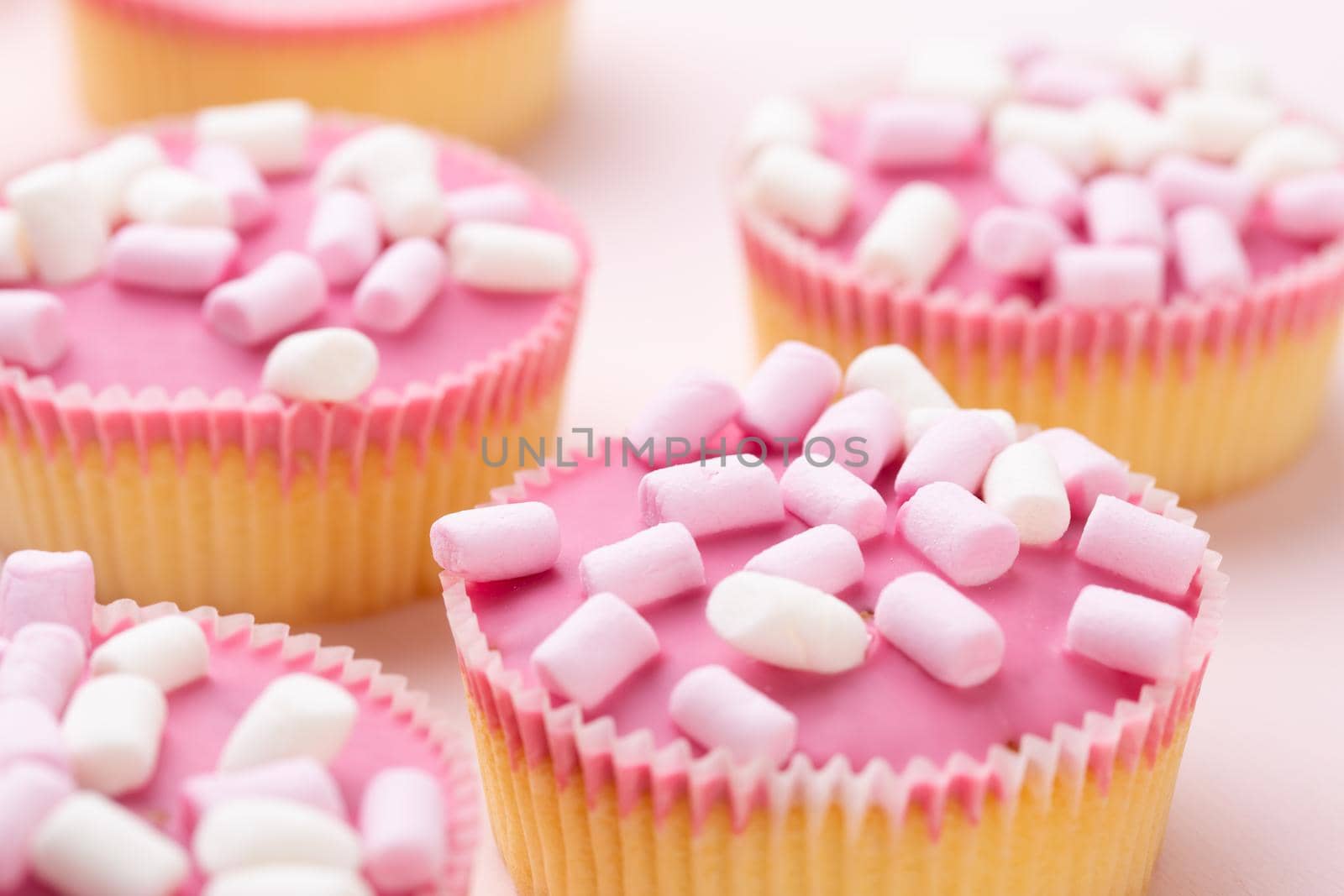 Colorful cupcakes on a pink background. by gitusik
