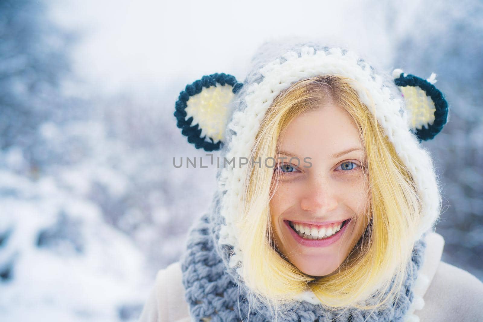 Beautiful winter portrait of young woman in the winter snowy scenery. Winter woman portrait outdoor. Model wearing stylish knitted winter hat and gloves