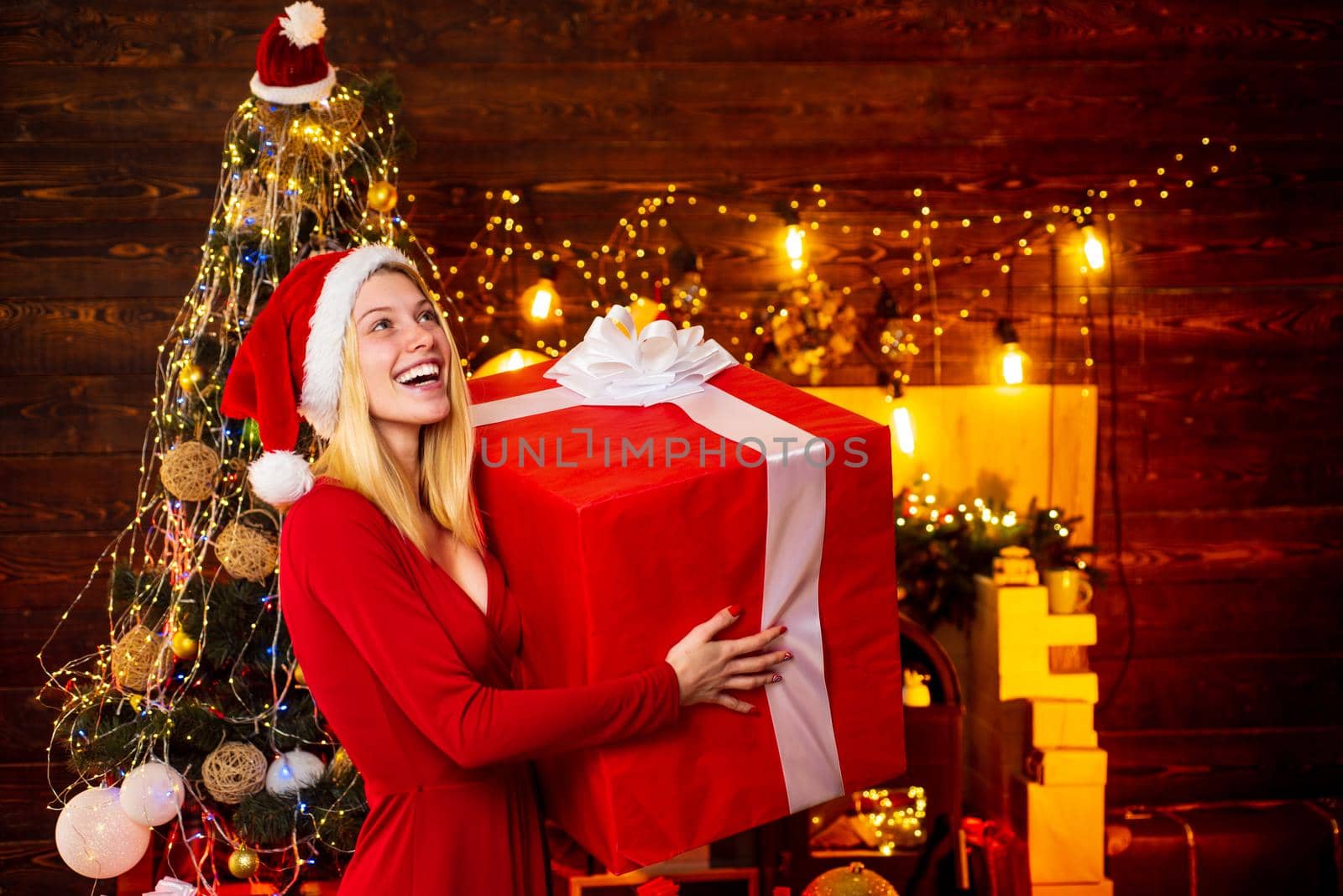 Woman with Christmas mood. Young woman in elegant red dress over Christmas interior background. Luxury Christmas woman. Christmas and new year holidays