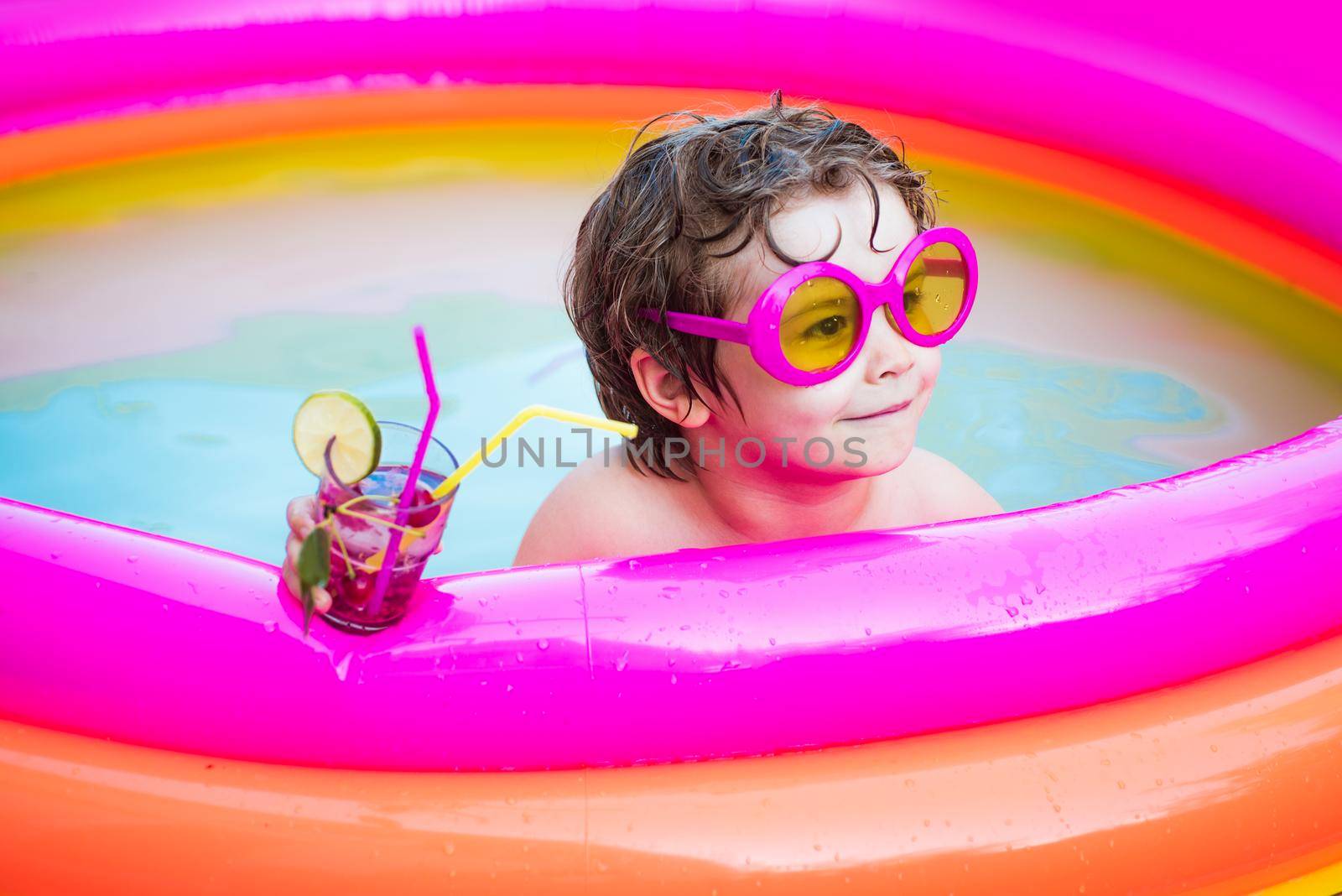Cute kids relaxed and drink cocktail in swimming pool. Child boy and best swimming pool. Beach party. Healthy outdoor sport activity for children. Vacation at Paradise