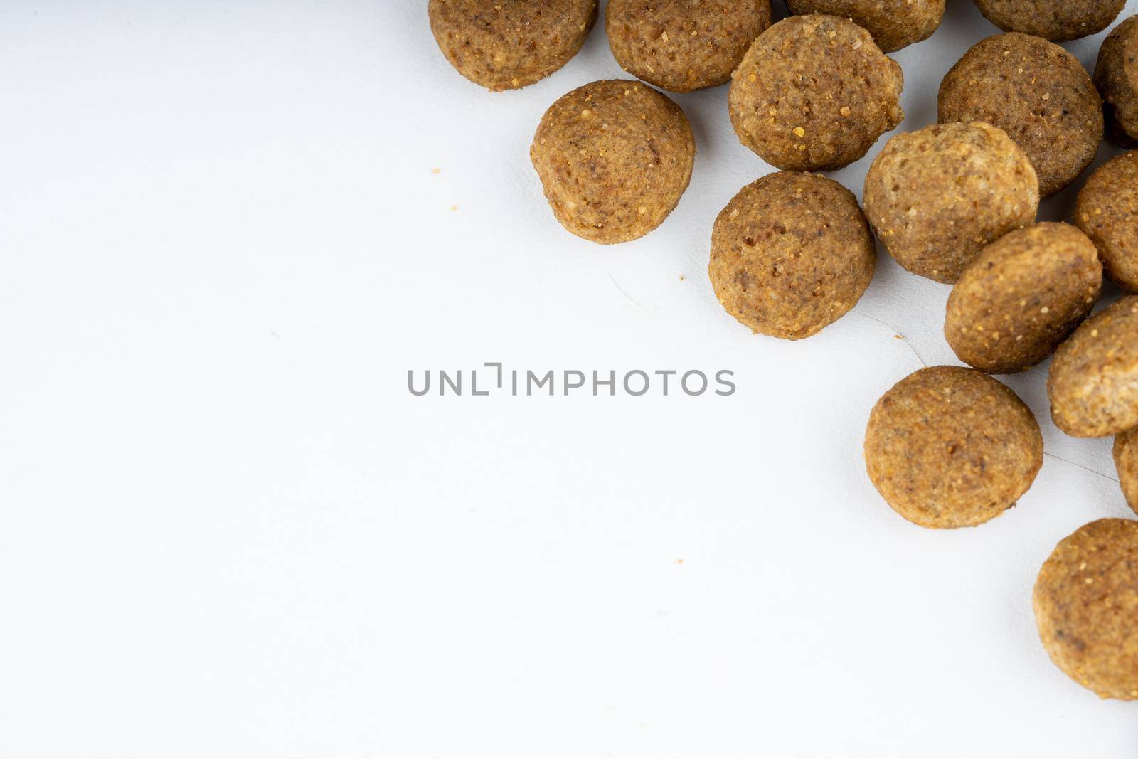 Dry food in right corner on white background. Close up of useful pet food. Concept of space for your text. by epidemiks