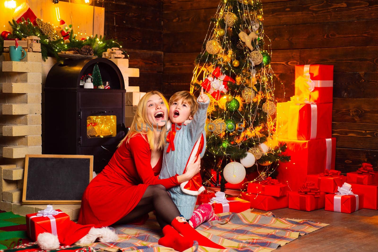 Surprised mum and child look up at sky and see Santa. Christmas gifts. New Year surprise present. Holiday discounts. Concept of Merry Christmas and New Year. Christmas shopping concept