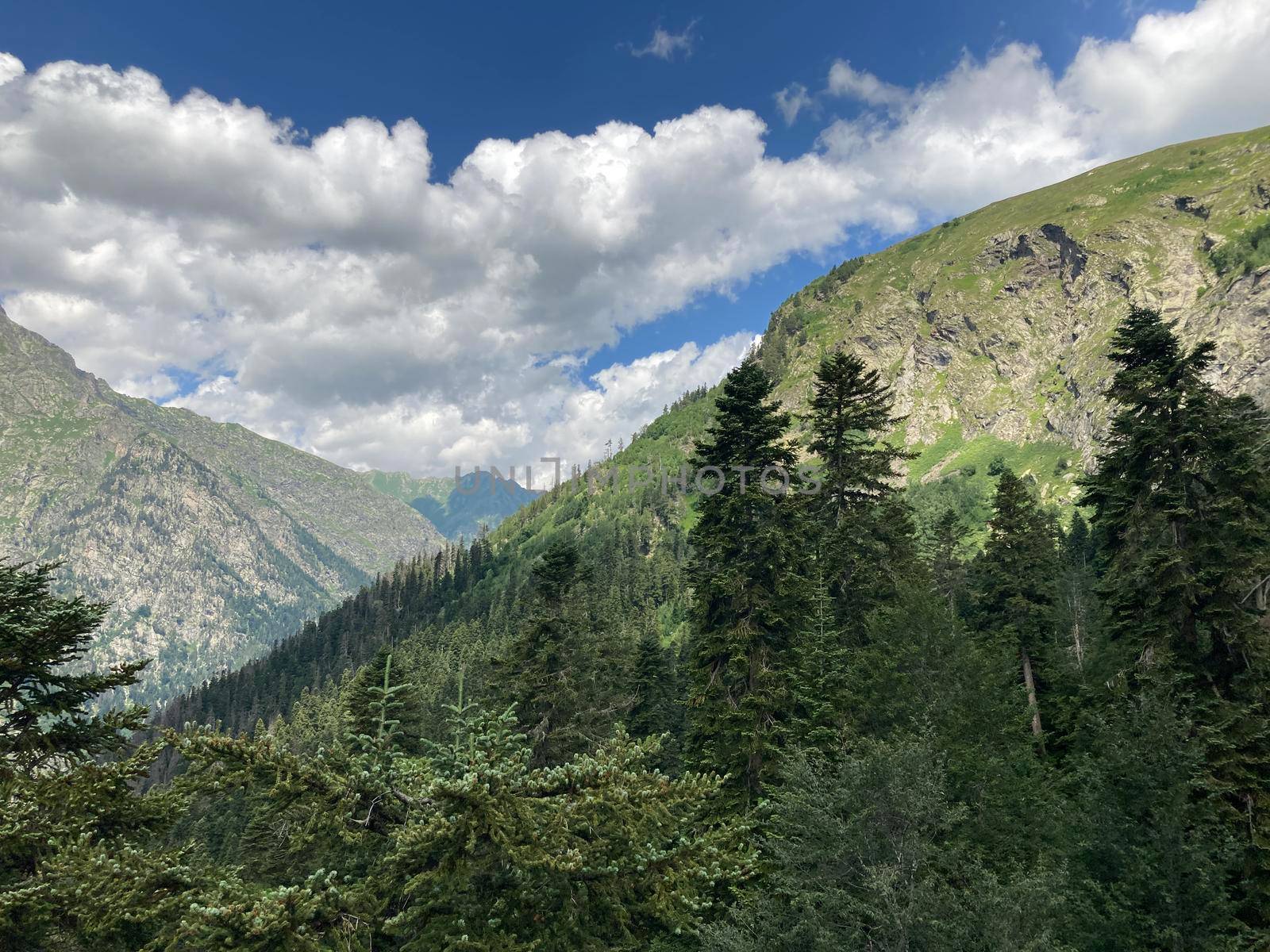 Peaks of magnificent rocks located against bright cloudy sky on sunny day in nature.