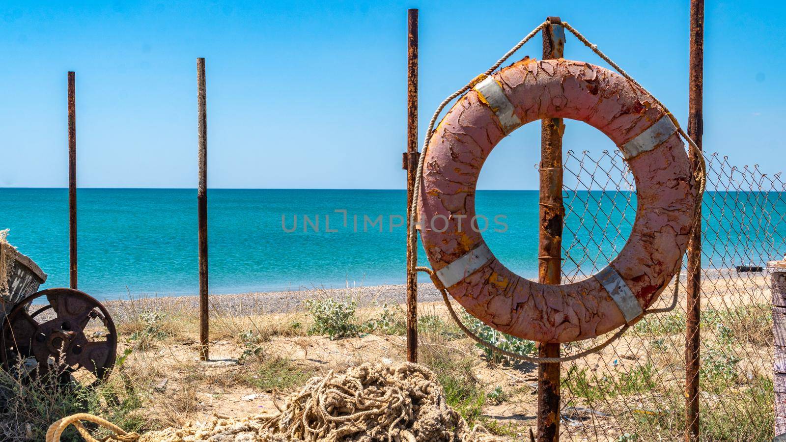 An old lifeline against the sea hangs on the beach all broken by 89167702191