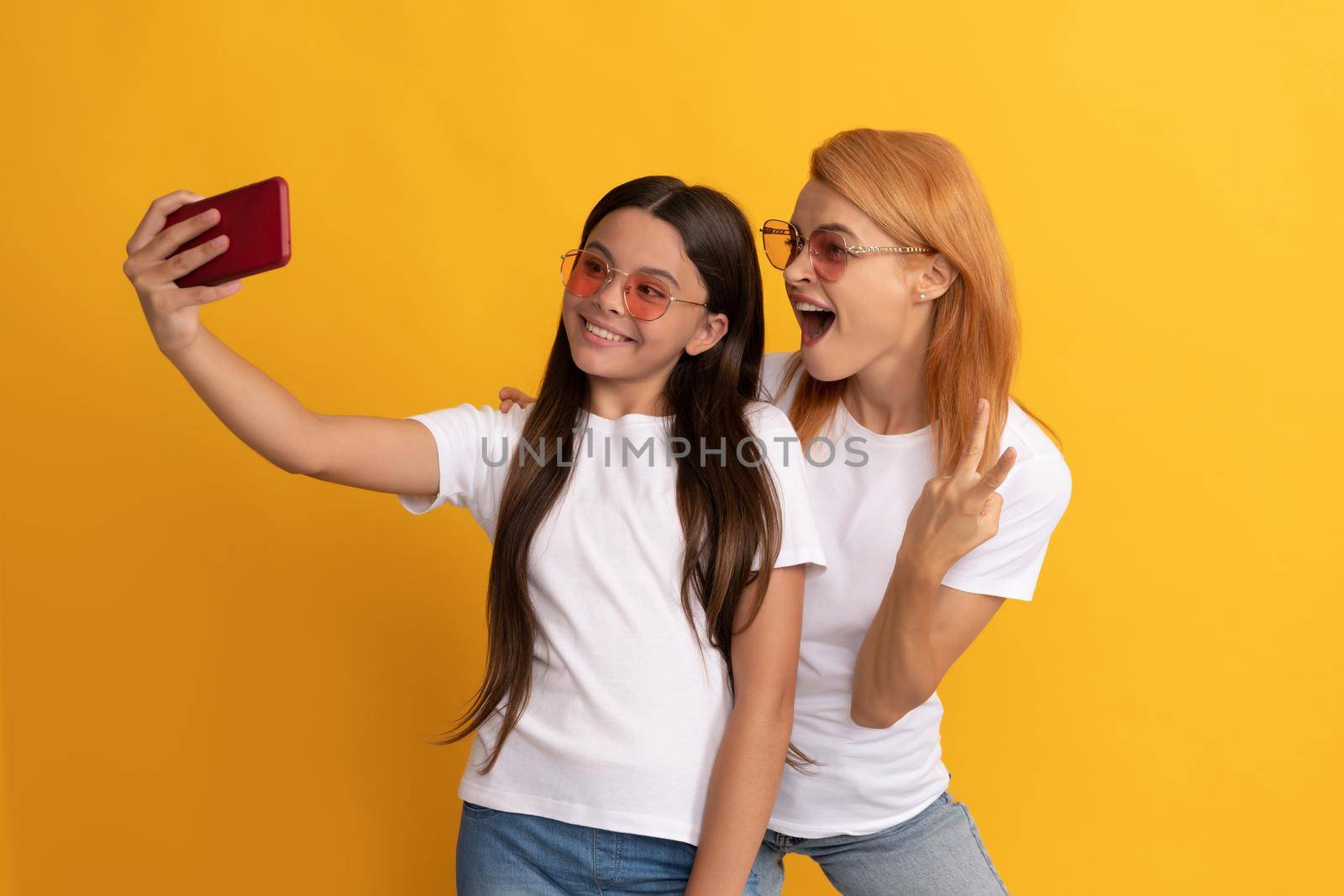having video call. mother and daughter vlogging. online communication. mom and kid bloggers. smiling woman and girl take selfie with smartphone. selfie family. modern life. mobile technology.