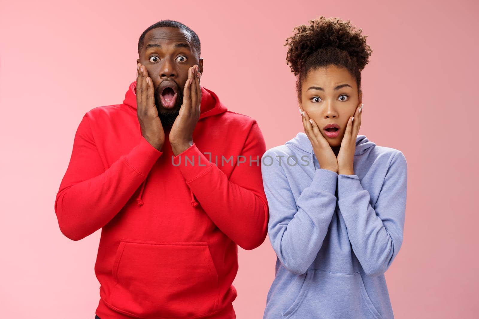 Amazed shocked gasping speechless two african american man woman drop jaw press palms cheeks worried nervous sympathizing terrible story standing stunned imrpessed pink background, feel sorry by Benzoix