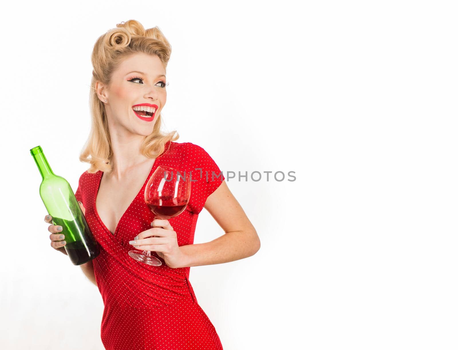 Smiling fashionable pinup girl. Beauty trends. Beauty. Happy girl with glass of wine. Beautiful blonde woman in red dress. Bright makeup. Happy excited woman in retro dress with beautiful hairdo