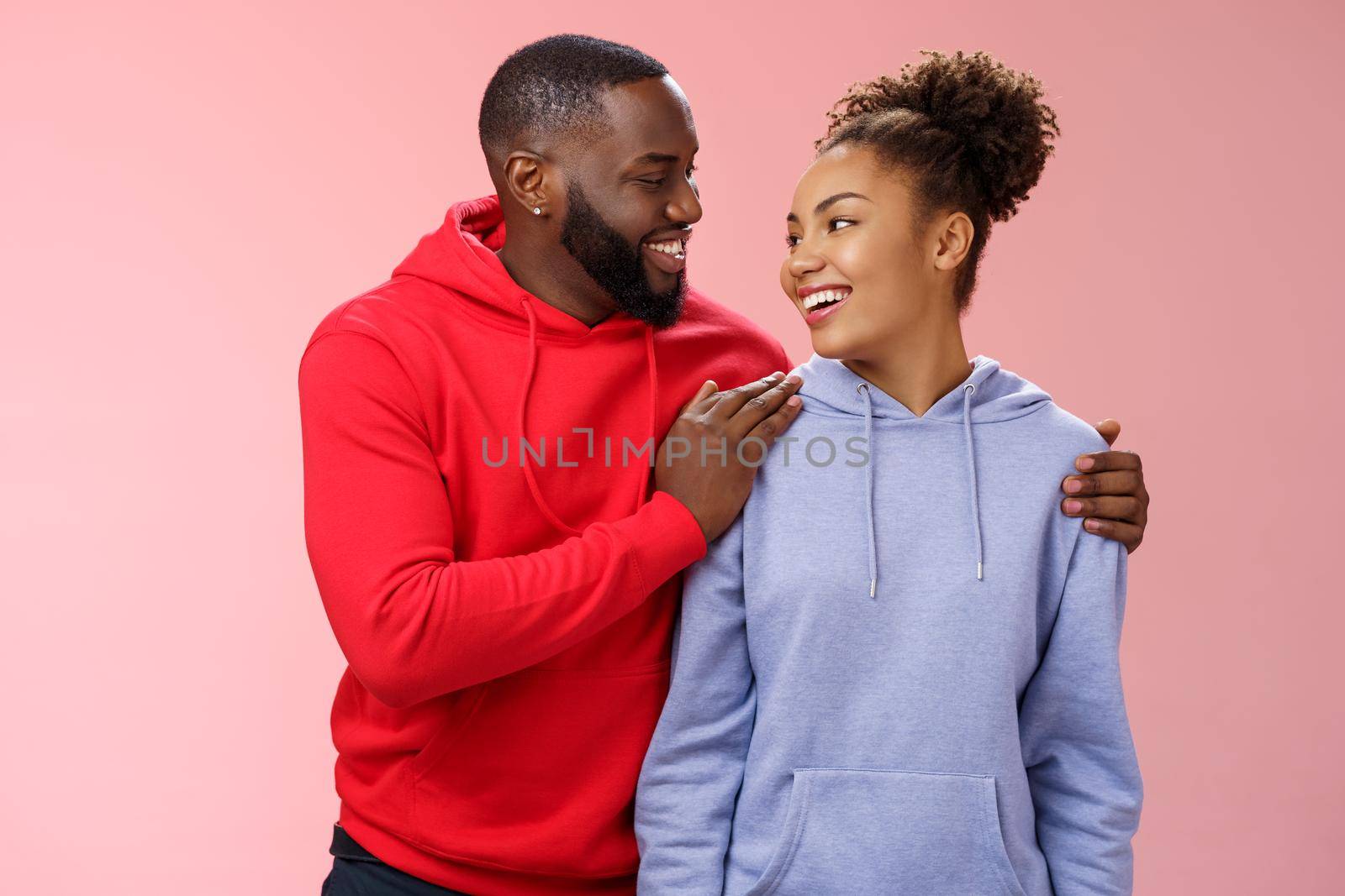 Charming lovely couple in love relationship support each other look caring passionate eyes smiling broadly heartwarming confession boyfriend hugging girlfriend feel secure, standing pink background.