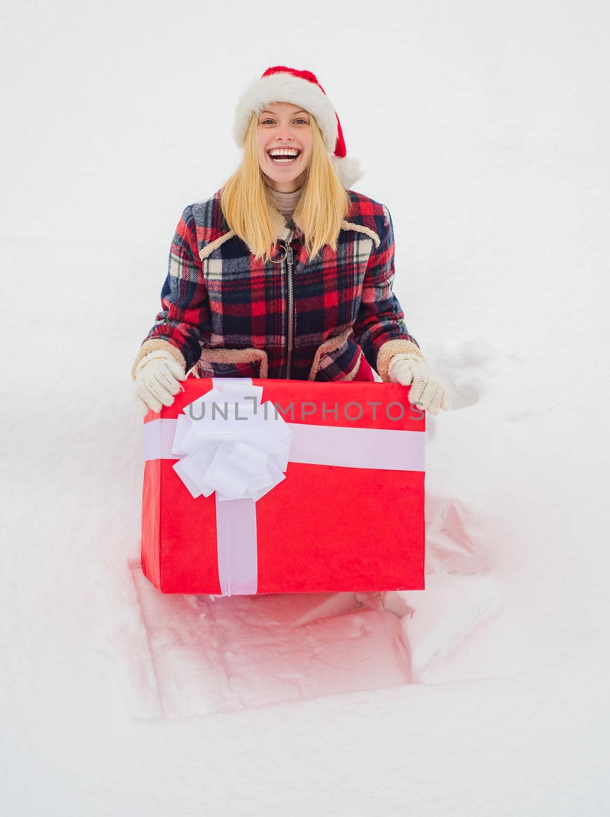 Christmas Girl holding a big gift. Happy woman with present or gift box outdoors. Big gift box. Funny Christmas woman and a big gift box. Winter emotion