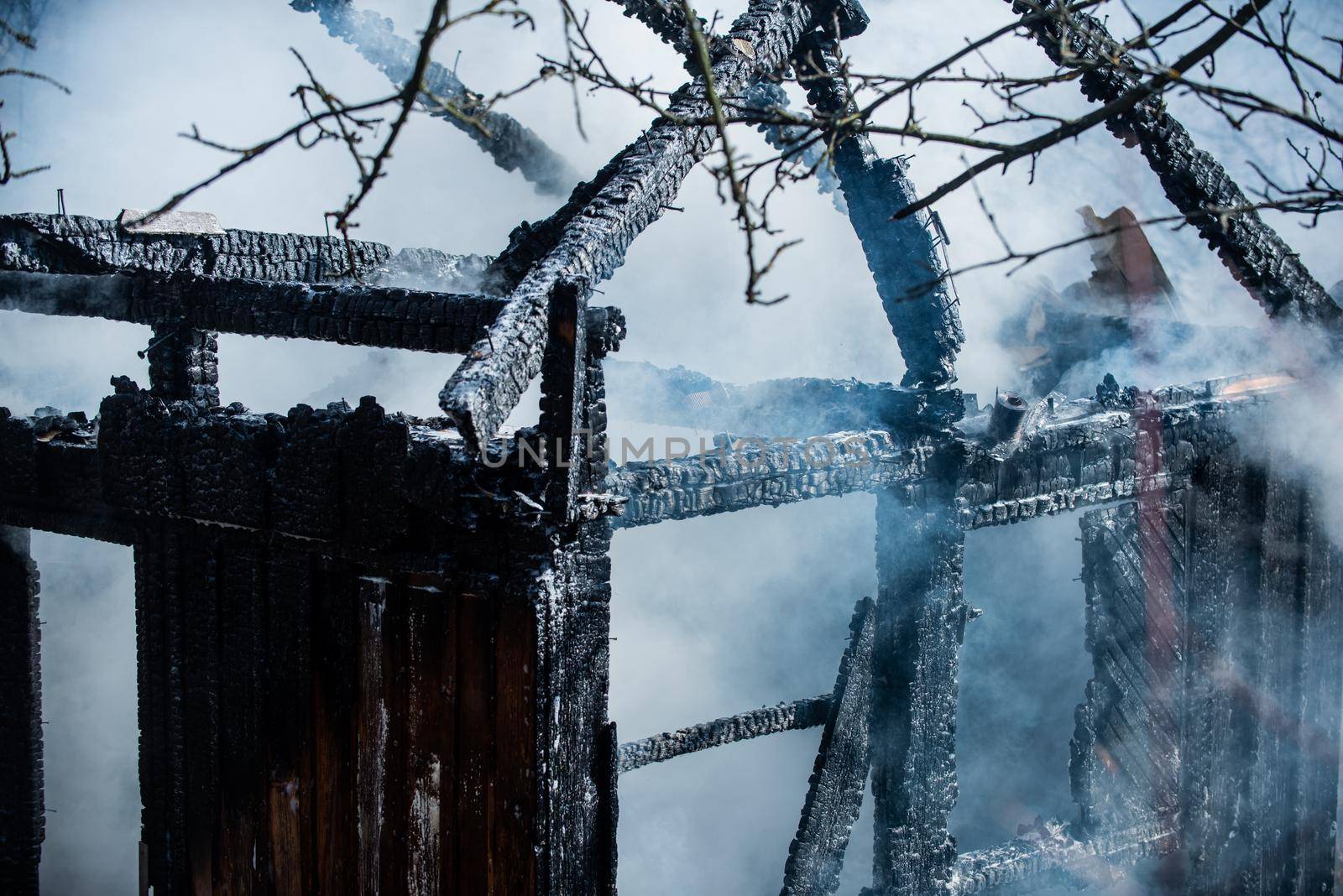 Burned down to the ground wooden house. Aftermath of fire disaster. Smoke after great fire