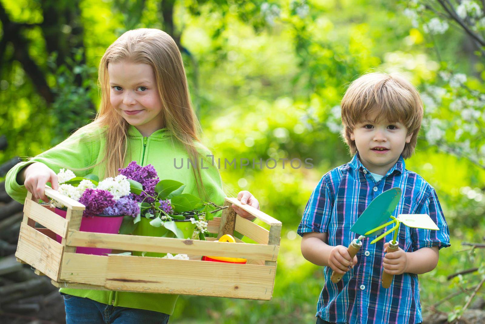 Countryside children. Cute boy and girl work in garden. Eco garden workers. Happy kids work. Mommy little helpers. Childchood and outdoor leisure concept. Young generation of tree huggers and nature lovers