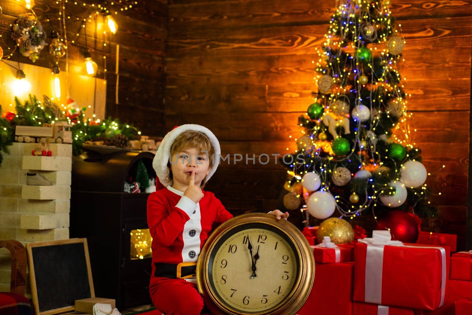 Christmas gifts. New year countdown. Happy child wait gifts. Christmas decoration. A little boy in santa clothes