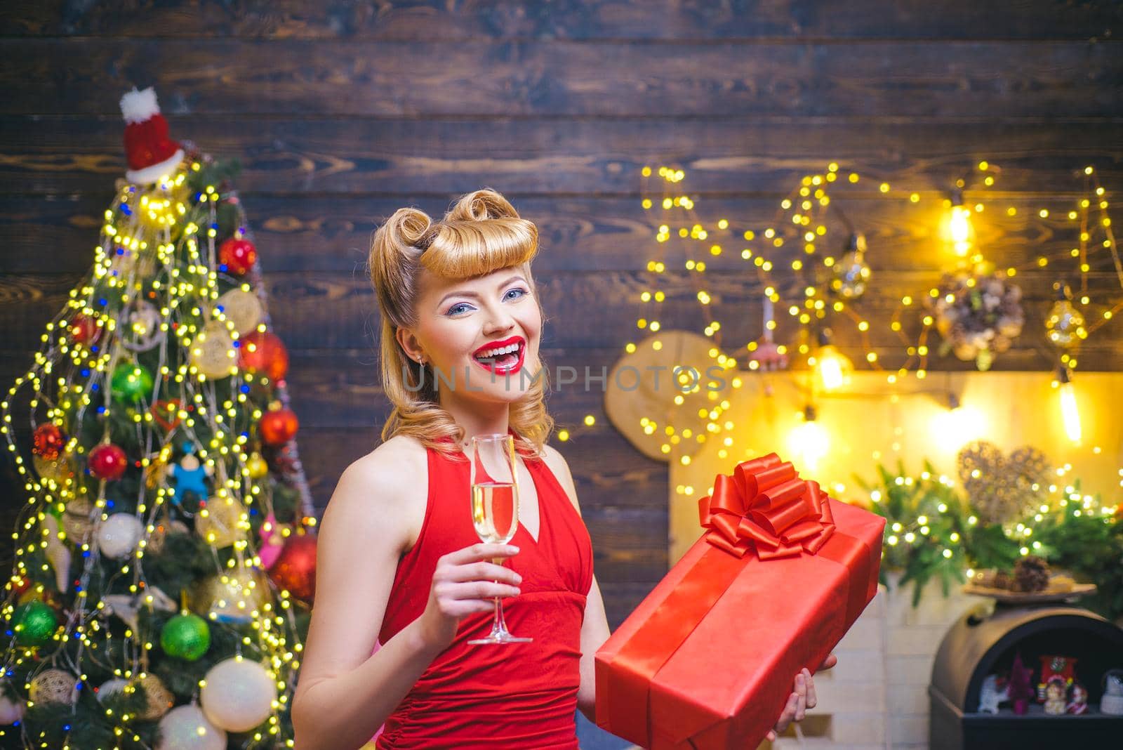 Beautiful happy woman with gift box at celebration party. Christmas celebration holiday. Beautiful girl with blond hair and red lips is holding a gift box