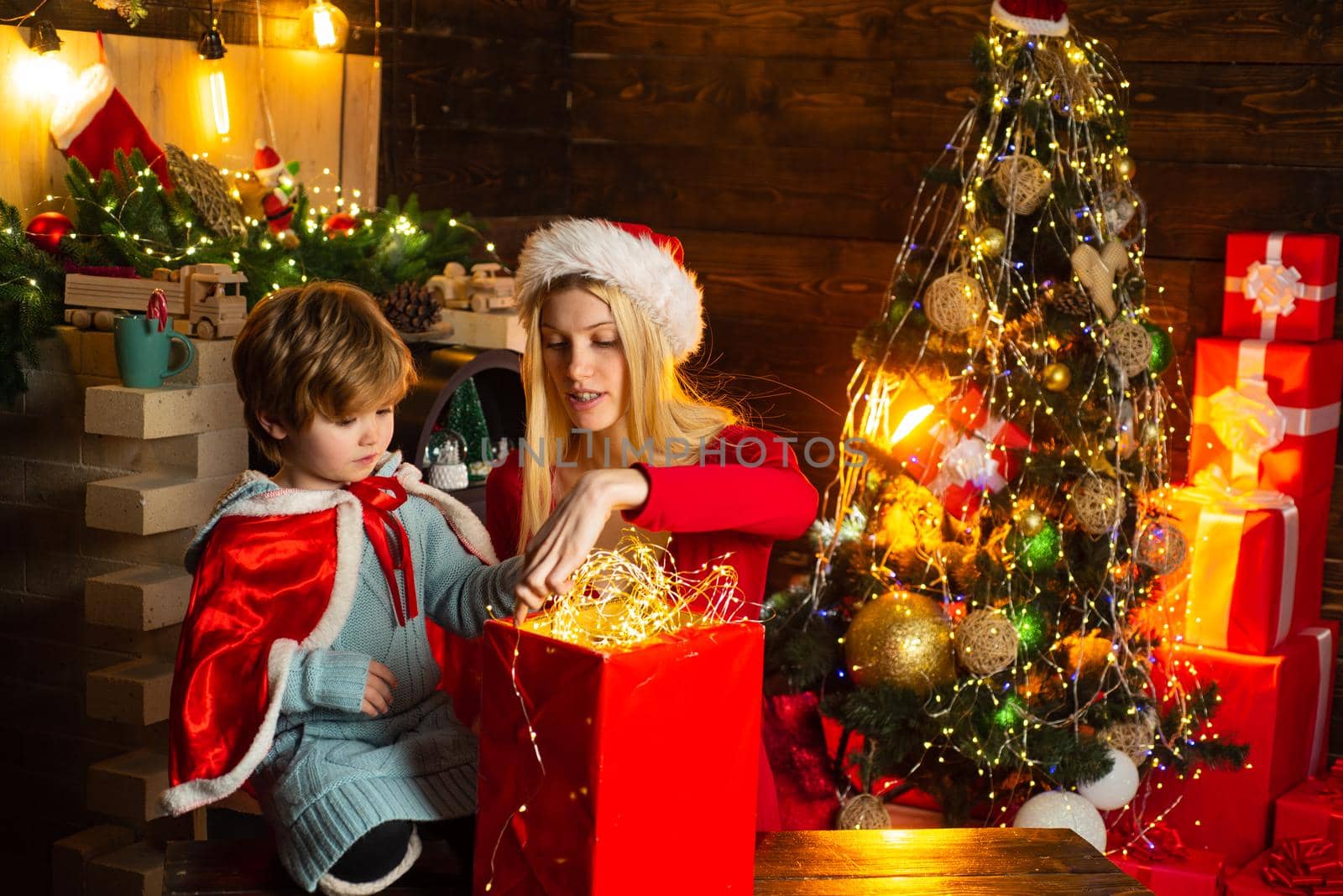 Family celebrate christmas. Mother with son and gift. Girl winter clothes santa claus hat celebrate christmas and happy new year. Christmas is coming