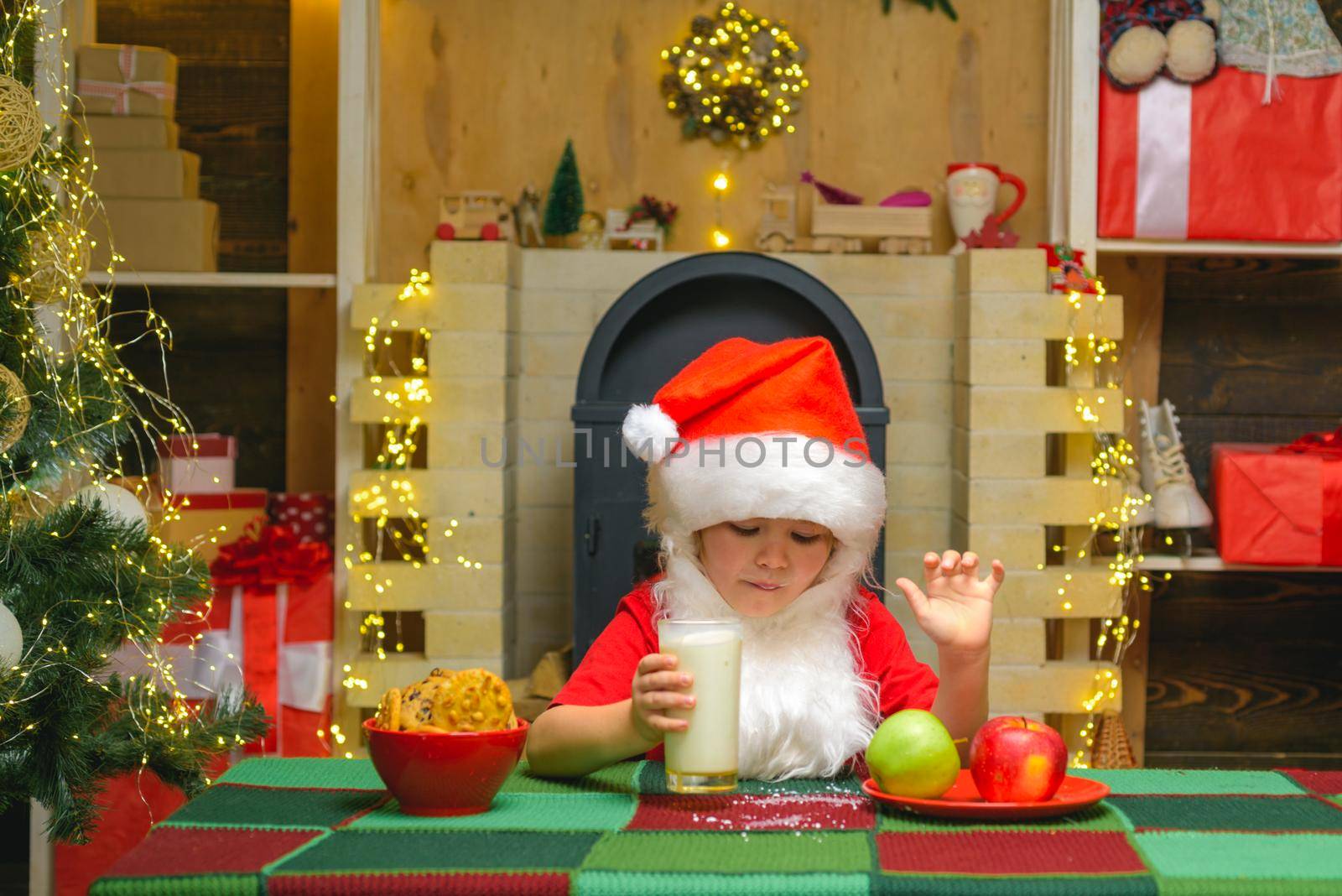 Portrait of Santa Claus Drinking milk from glass and holding cookies. Santa Claus takes a cookie on Christmas Eve as a thank you gift for leaving presents