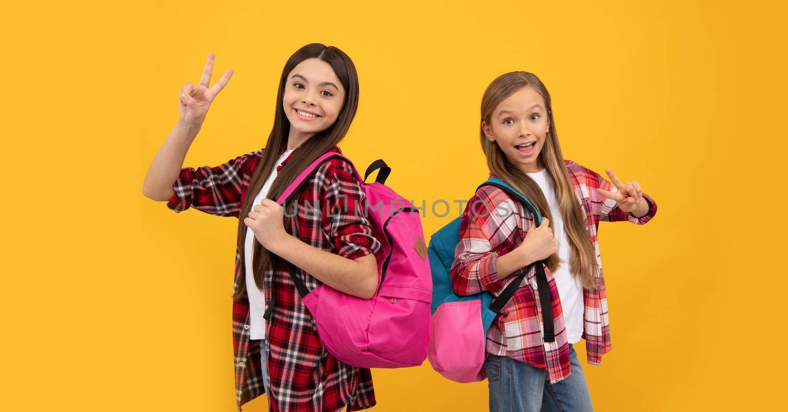 back to school. knowledge day. concept of education. kids with long hair on yellow background. september 1. happy childhood. children with school bag. cool teen girls carry backpack.