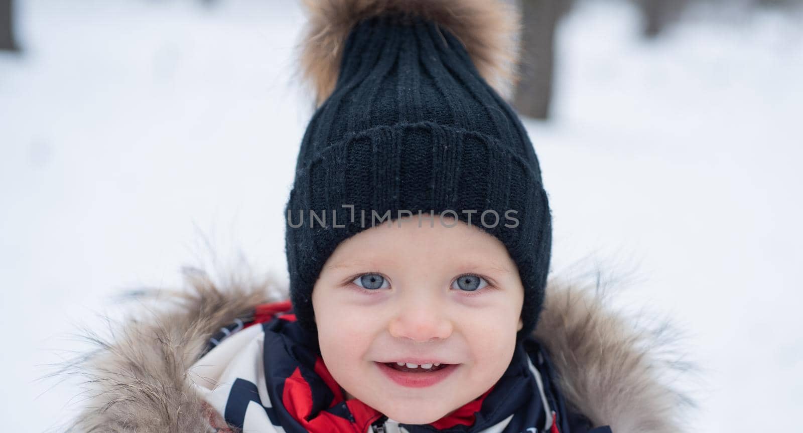 Cute little boy in winter park. Christmas and New Year holidays. Snowy cold weather. Winter holidays. Beautiful winter nature. Little boy in warm winter clothes having fun