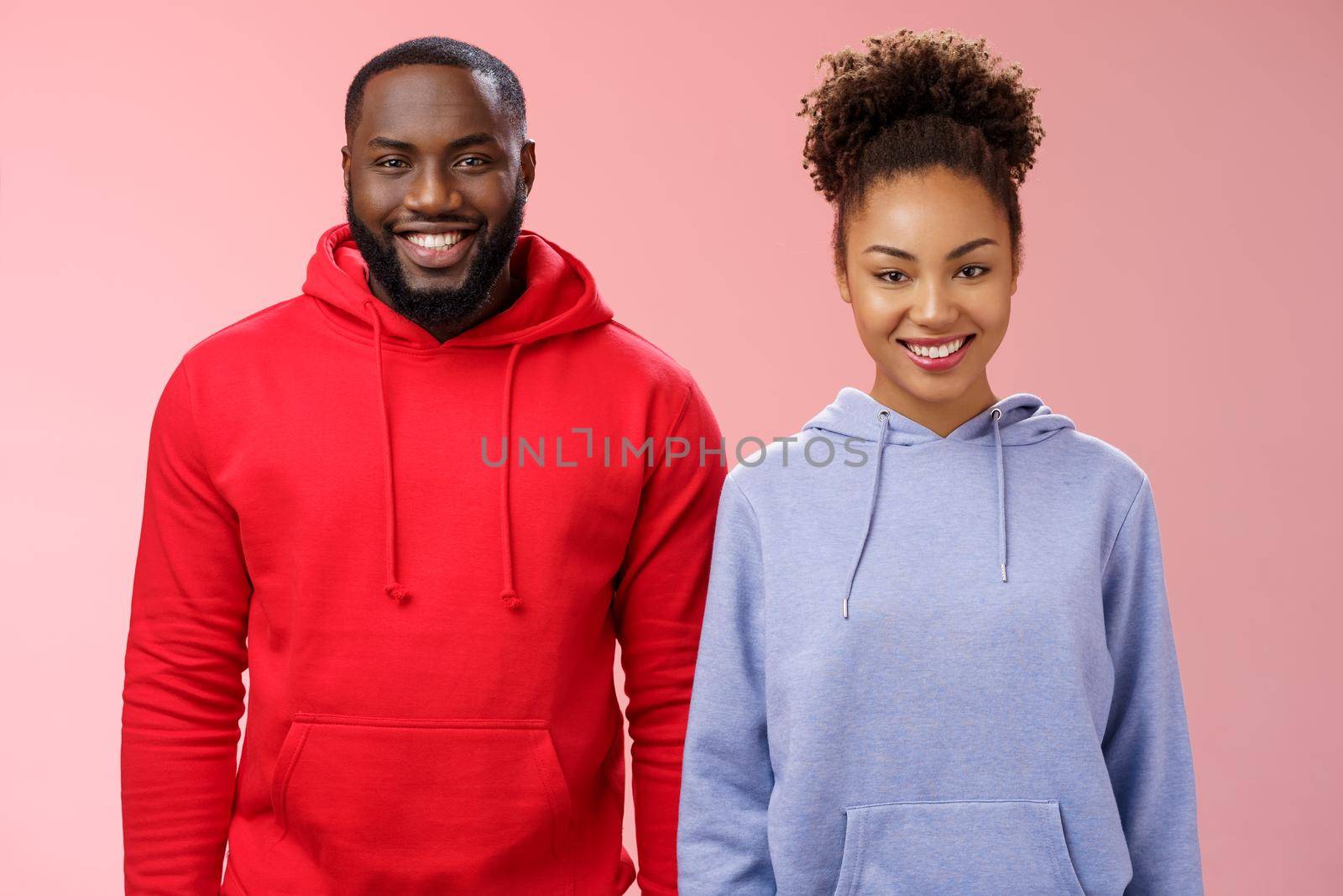 Friendly two african american man woman standing together smiling broadly coworkers present collective project receive good feedback grinning delighted like working pair, standing pink background.