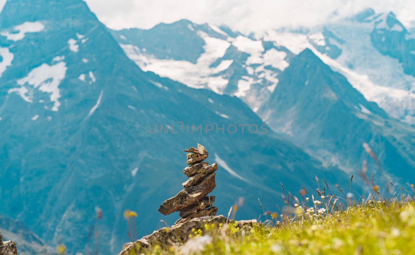 Close up of pile of stones on ground against mountain landscape. Decoration of stones on top of mountain on summer day. by epidemiks