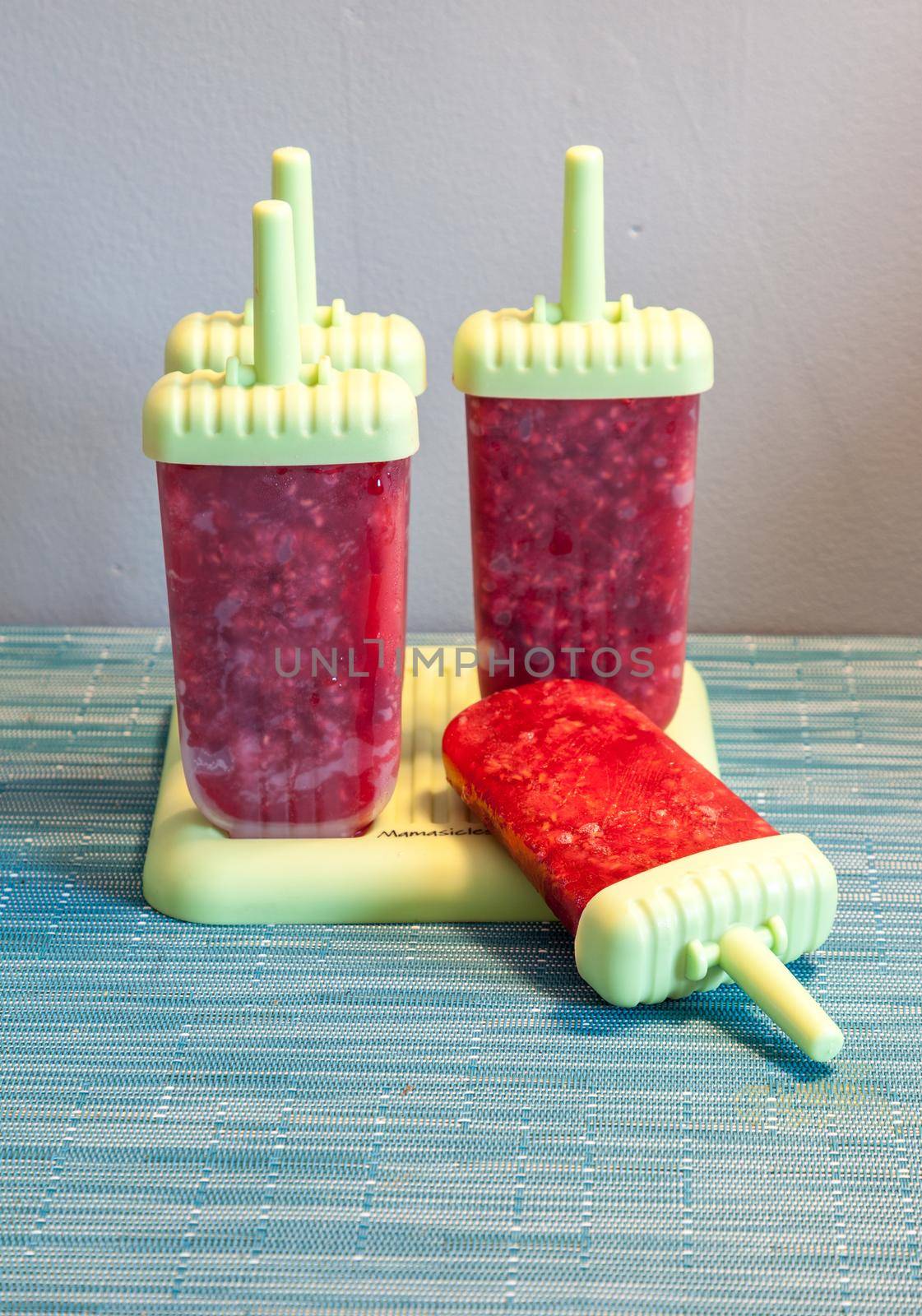 Homemade raspberry popsicles in a green mold by steffstarr