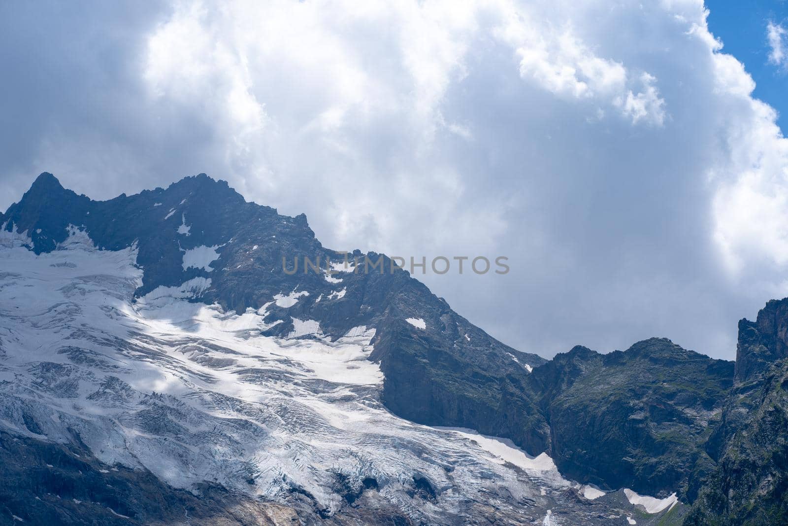 Beautiful mountain landscape in summertime. Mighty mountains with snow in cloudy weather. by epidemiks