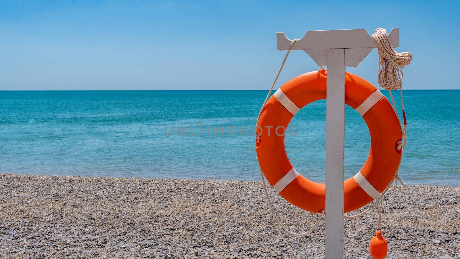 Rescue circle on the ocean on a beautiful sandy beach, in sunny weather, beautiful photo for advertising the seas and recreation