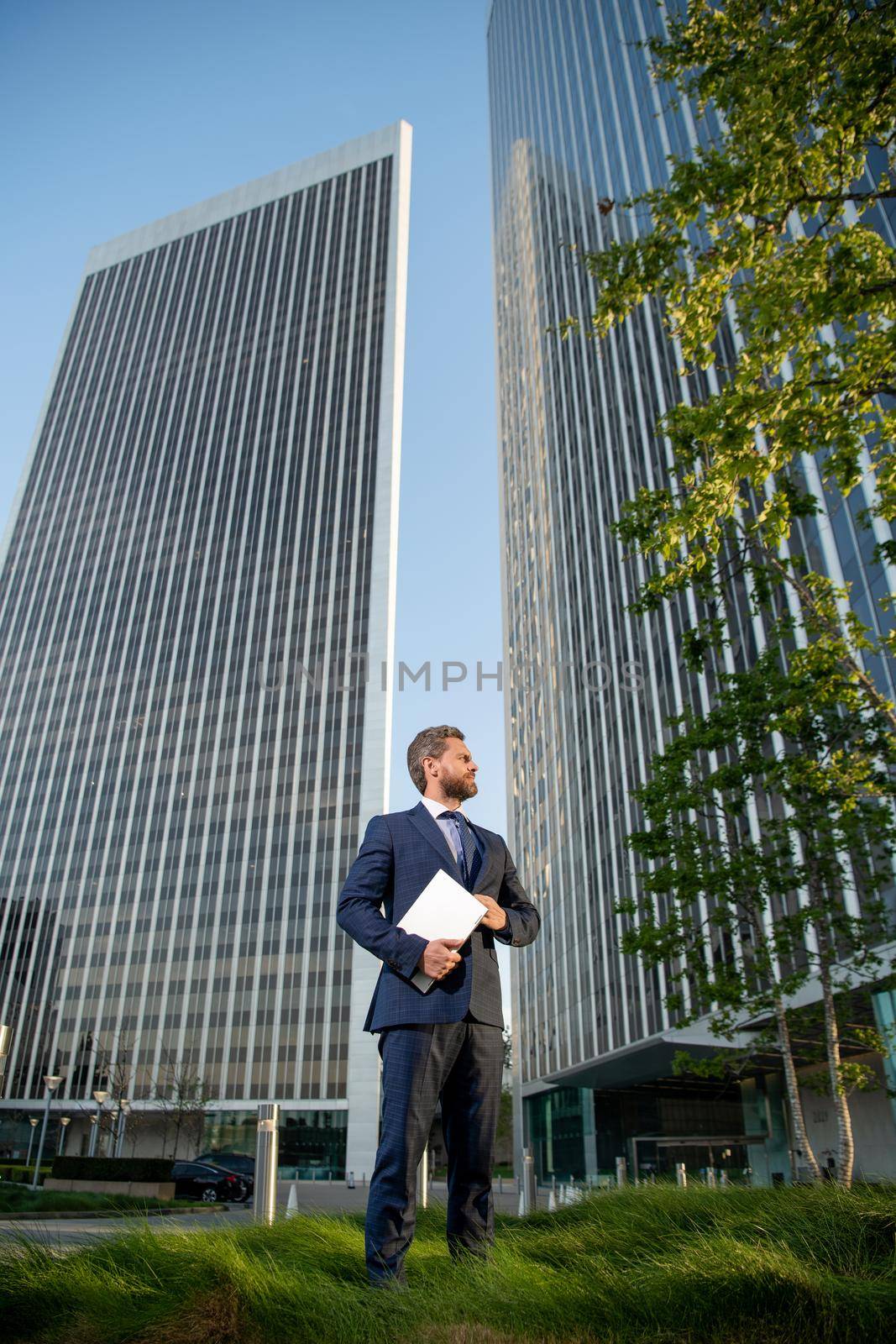 entrepreneur. agile business. professional network administrator hold computer. boss with modern wireless laptop. full length. businessman outside the office. business success. manager man hold pc.