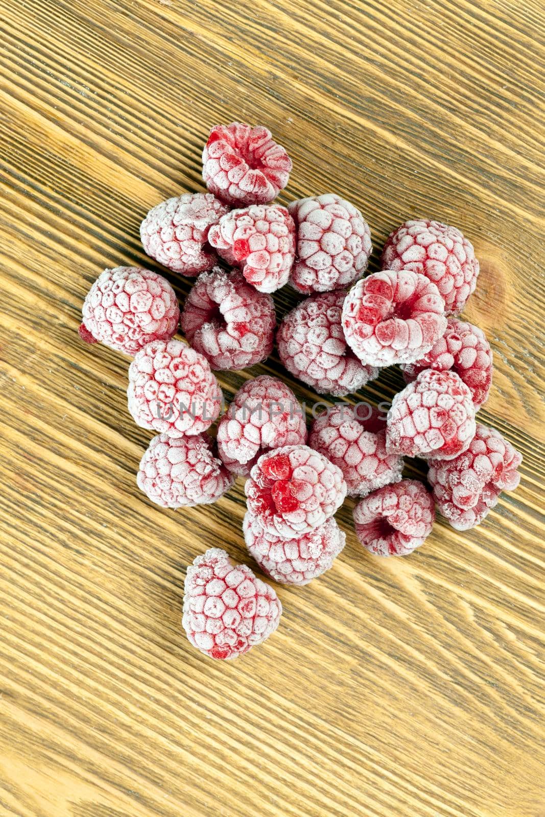 frozen raspberries during defrosting, photo closeup with frosted crystals