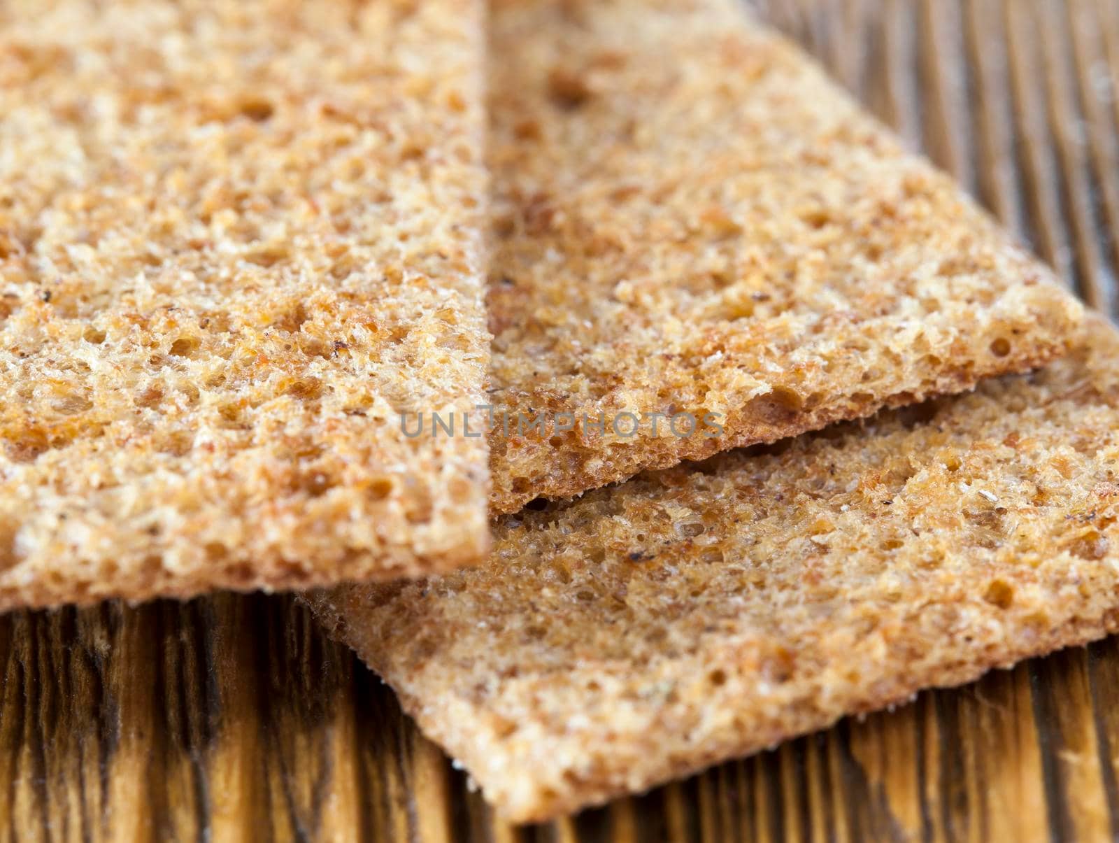 thin dry bread from rye flour, ready to eat, closeup meal on a wooden table