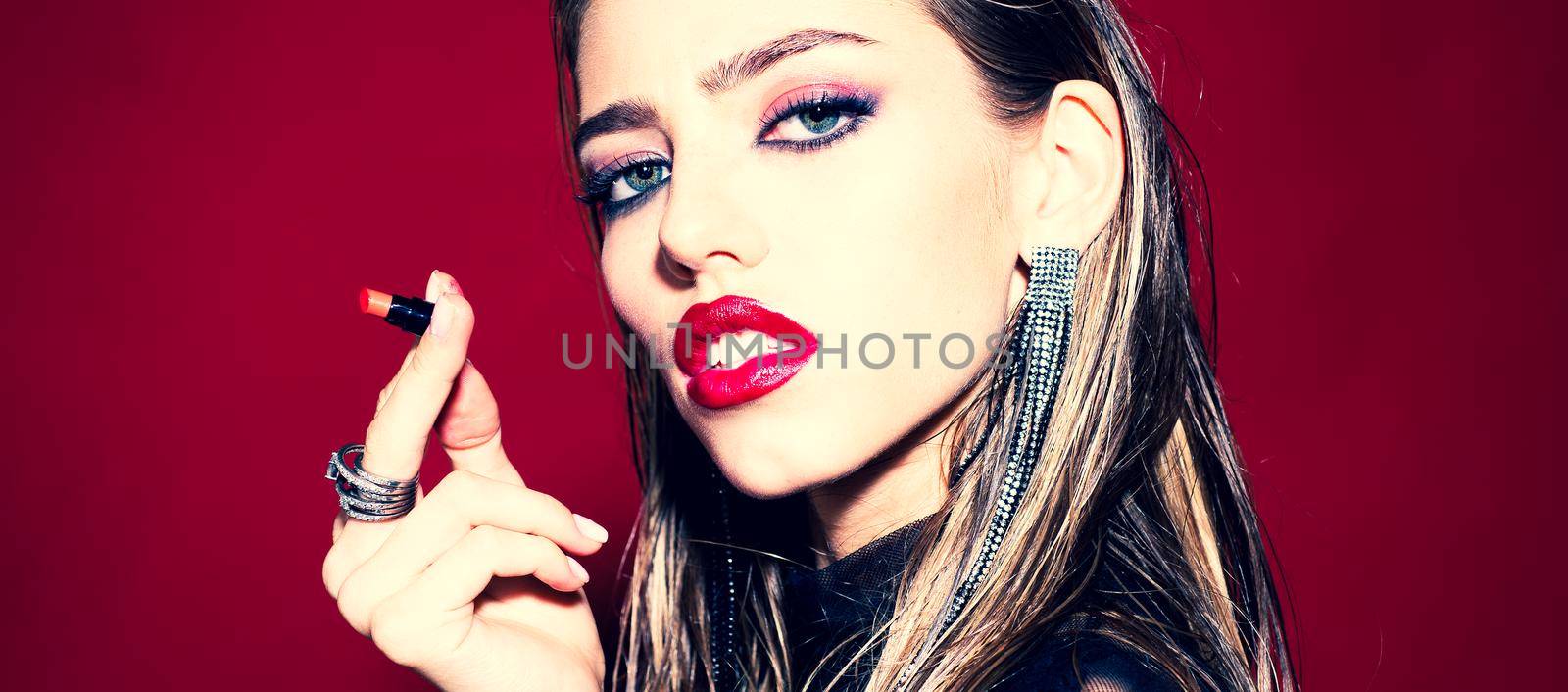 High fashion. Beauty face of the young beautiful woman - isolated on red. Great of women lips. High fashion model woman with colorful trendy make-up. Facial treatment