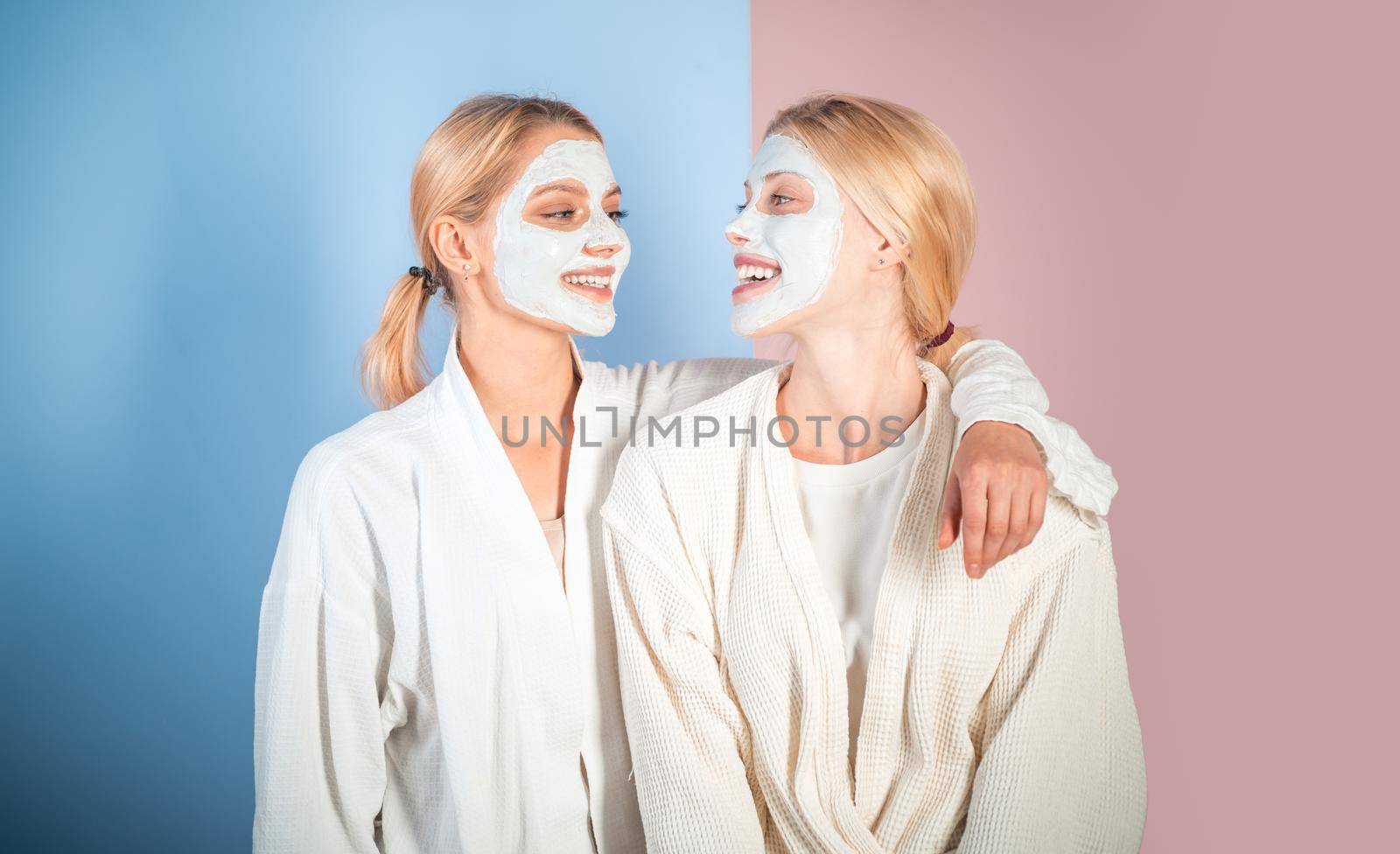 Young women enjoying of facial mask treatment and have a good time with spa procedures. Health and beauty concept. Best friends doing spa procedures and having fun