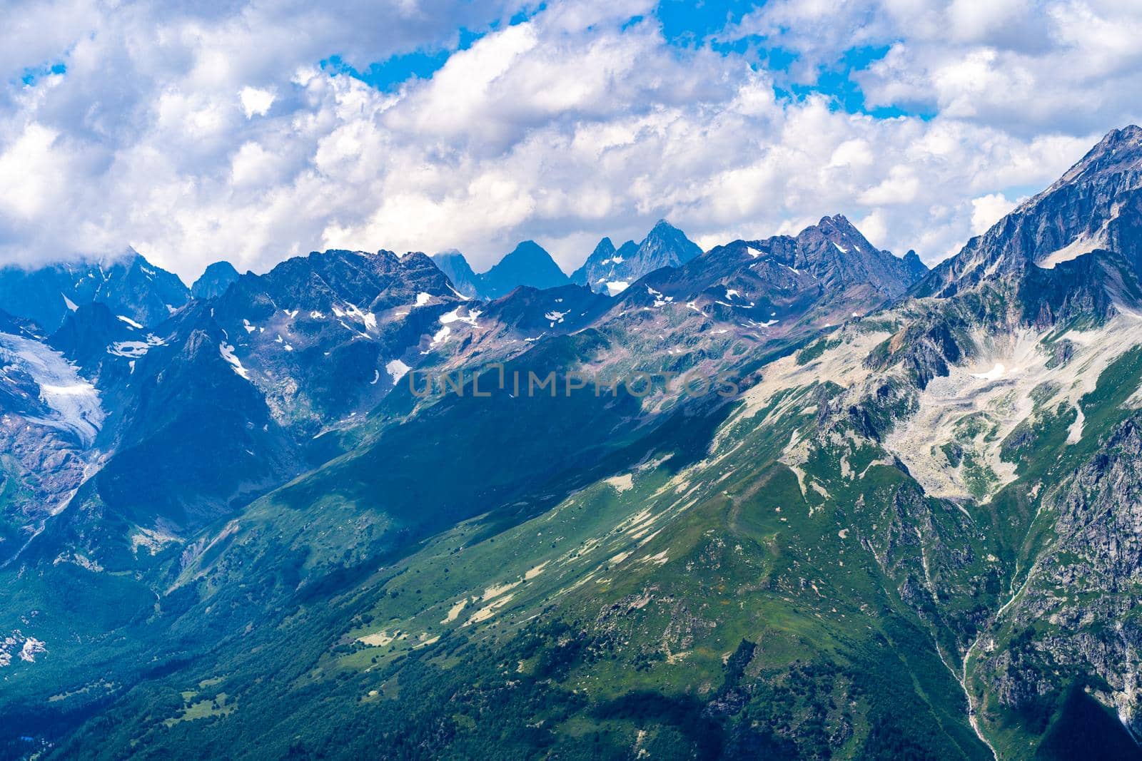 Peaks of magnificent rocks located against bright cloudy sky on sunny day in nature.