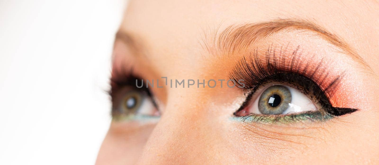 Close up eyes of a woman. Portrait of a beautiful girl.The pupil and iris of the eye close-up. Young woman with glitter makeup. Pin up style make up.Close up grey eye with bright makeup. Macro shot with perfect skin