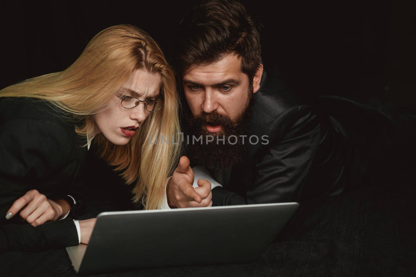 Two business partners working with laptop together. Couple guy and girl surfing internet in laptop. Portrait of business people