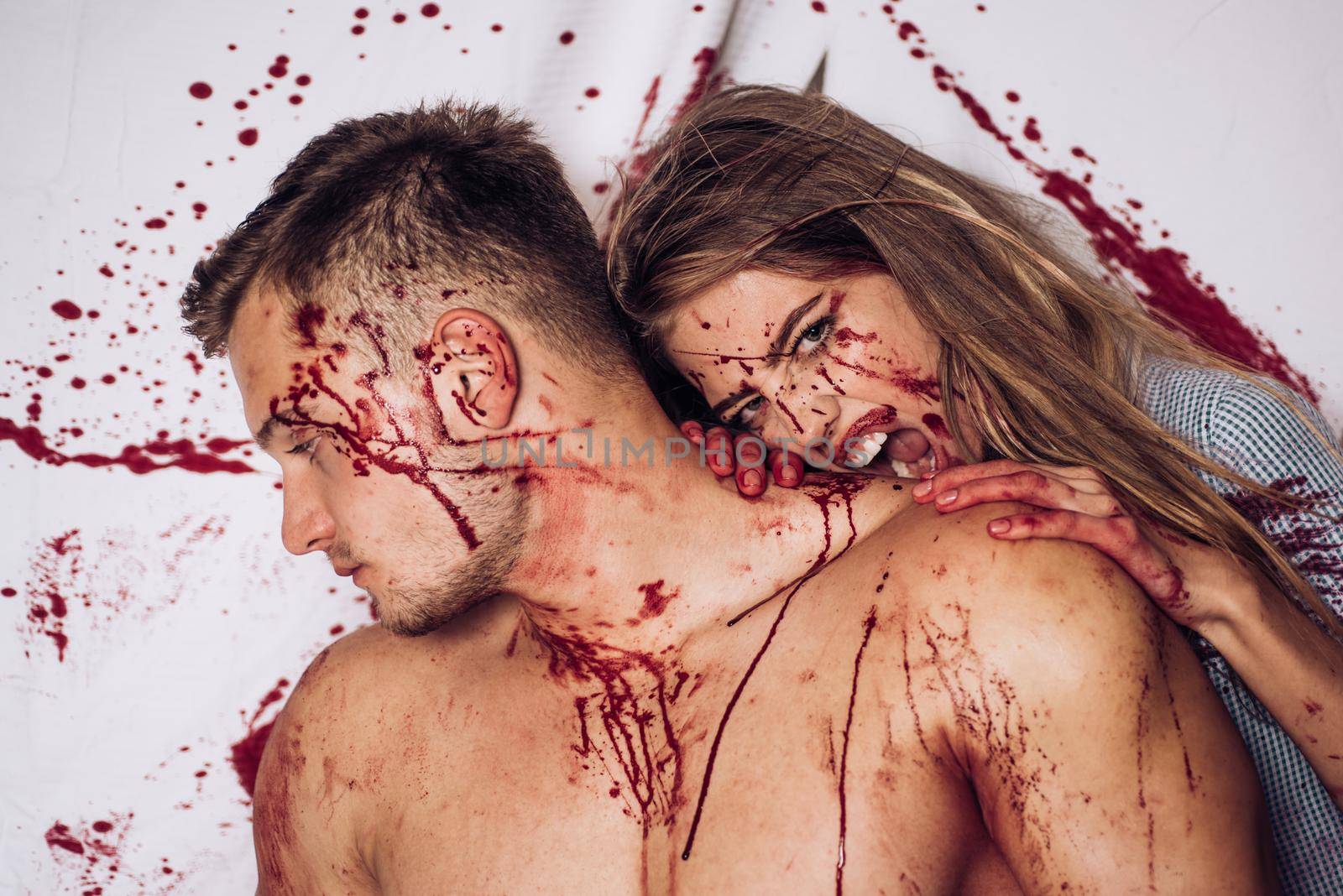 Bloody halloween couple in love. Together. Strong man wearing butcher apron with blood stains. Happy Halloween