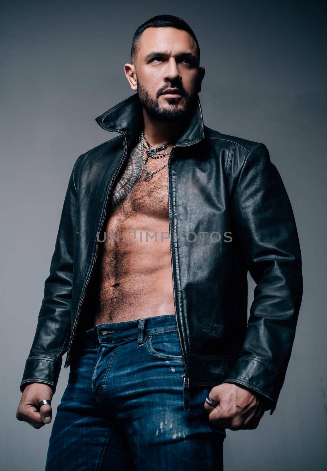 Side view portrait of confident bearded man with beautiful hairstyle in black jacket. Young handsome hipster ginger bearded guy looking brutal. Isolated on black background