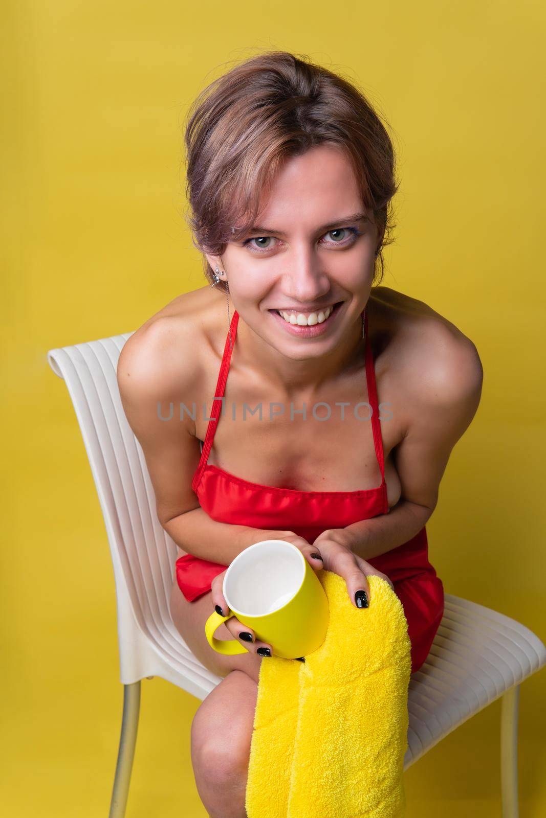 Girl cleans up with a rag and a cup on a yellow background in a red apron housekeeping female domestic, tidy untidiness hand housekeeper are. Ogether young top , iew portrait protective rubber housewife working holding