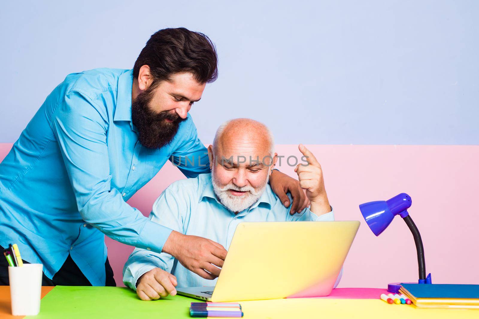 Two colleagues working together at office on color background. Corporate business colleagues working together in color office