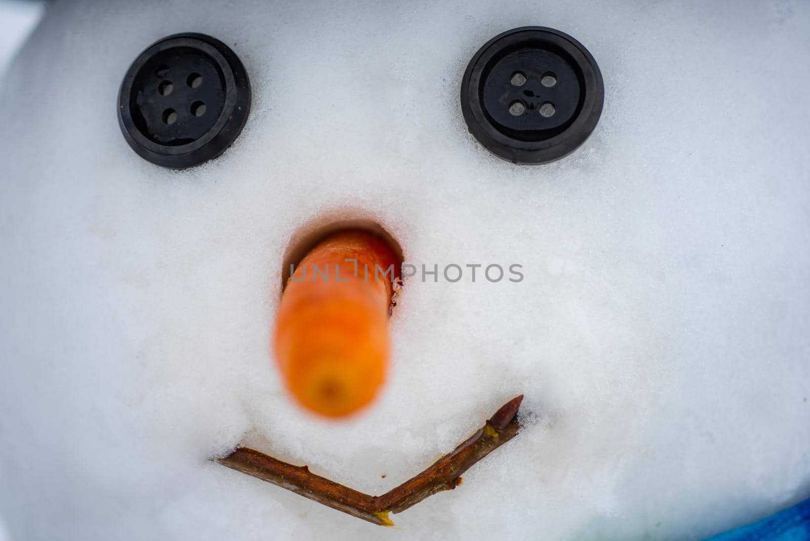 Happy funny snowman in the snow. New year Christmas concept. Snowman with red nose and black eyes button