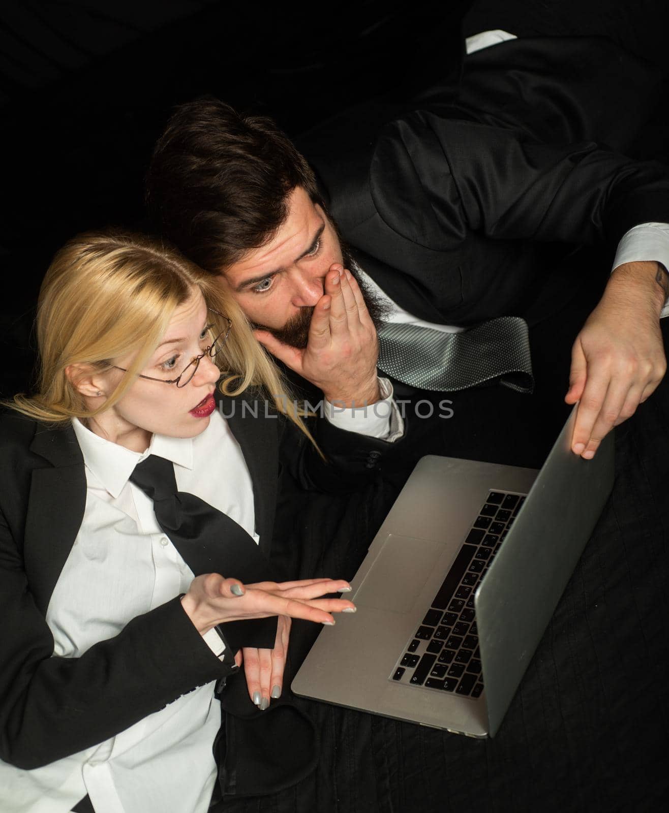 Two business partners working with laptop together.Beautiful young business woman and handsome businessman in formal suits are using a laptop. by Tverdokhlib