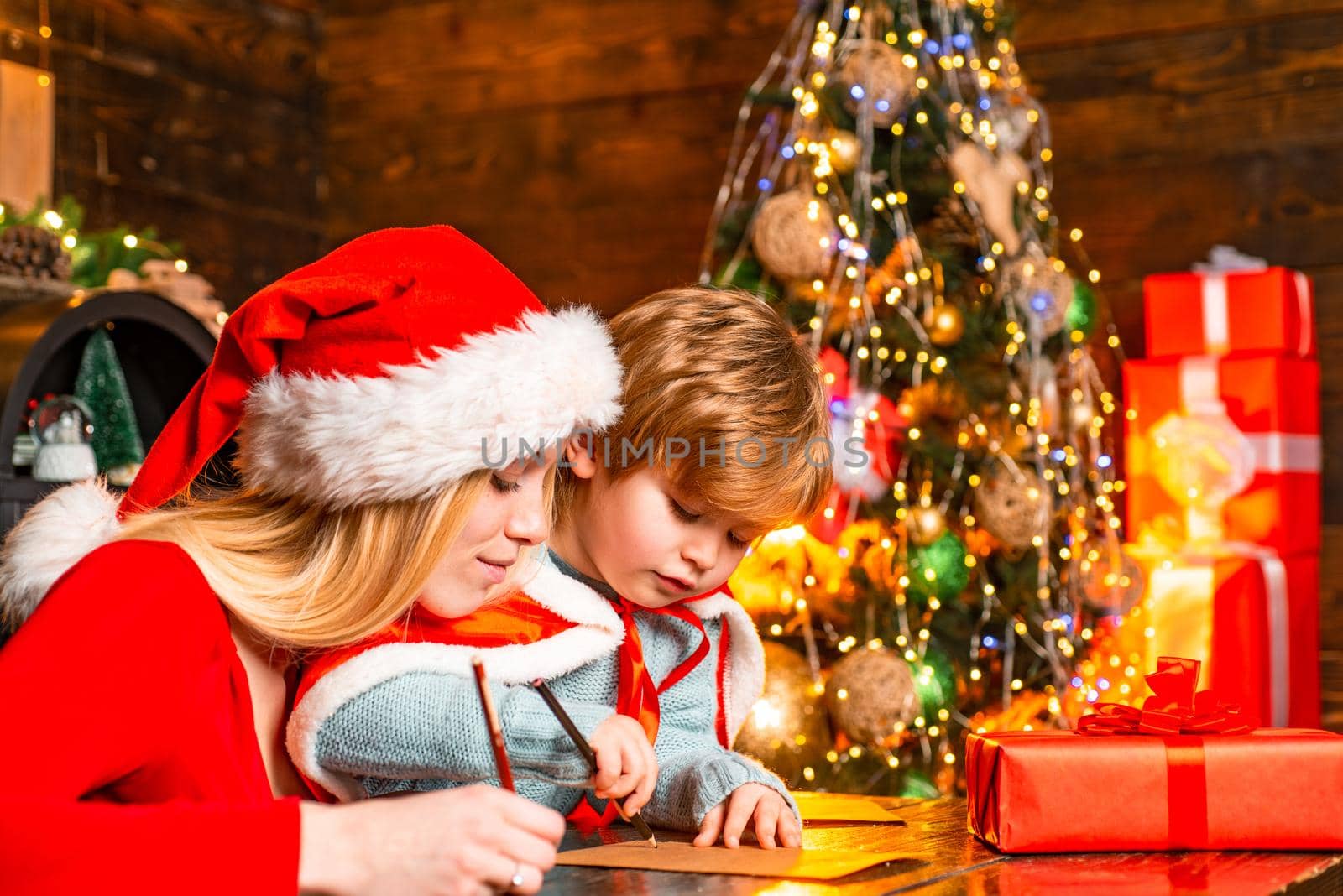 Mum and kid writing a letter to Santa with wish list of Christmas presents.Christmas interior. Merry christmas and happy new year. Bright New Years interior concept