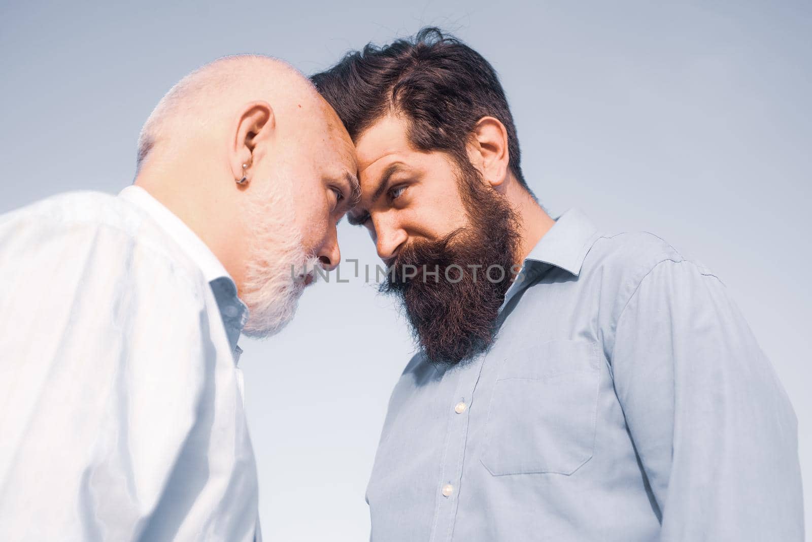 Father and son looking at each other. Retirement parent. Men generation. Two different generations ages: grandfather and father together